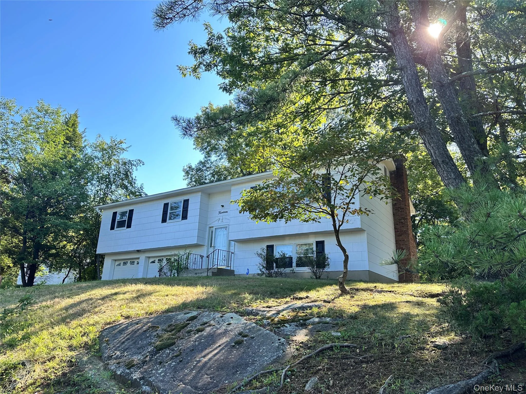 Raised ranch with a front lawn and an attached garage Raised ranch with a front lawn and an attached garage
