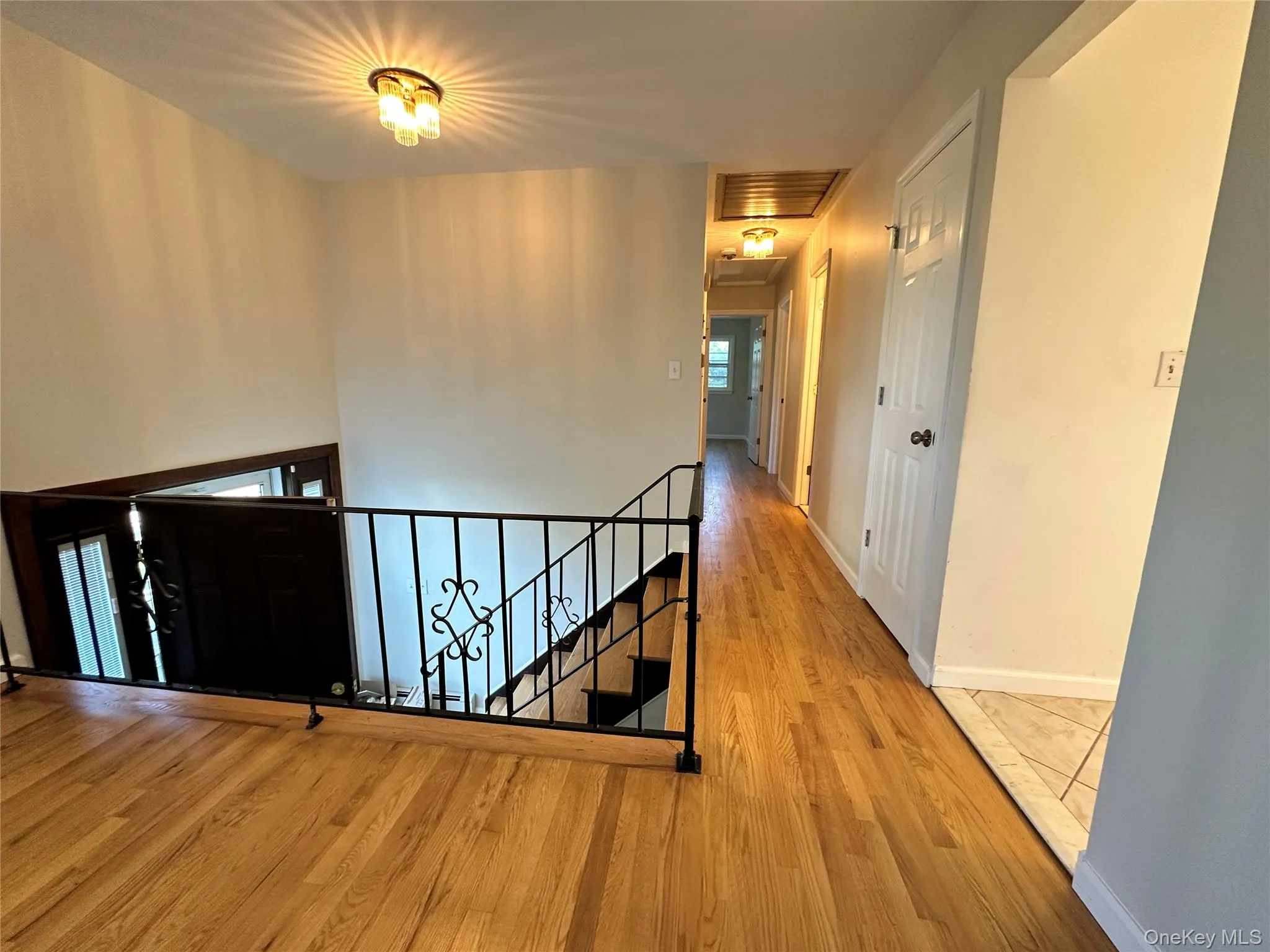 Hallway with an upstairs landing and wood finished floors Hallway with an upstairs landing and wood finished floors