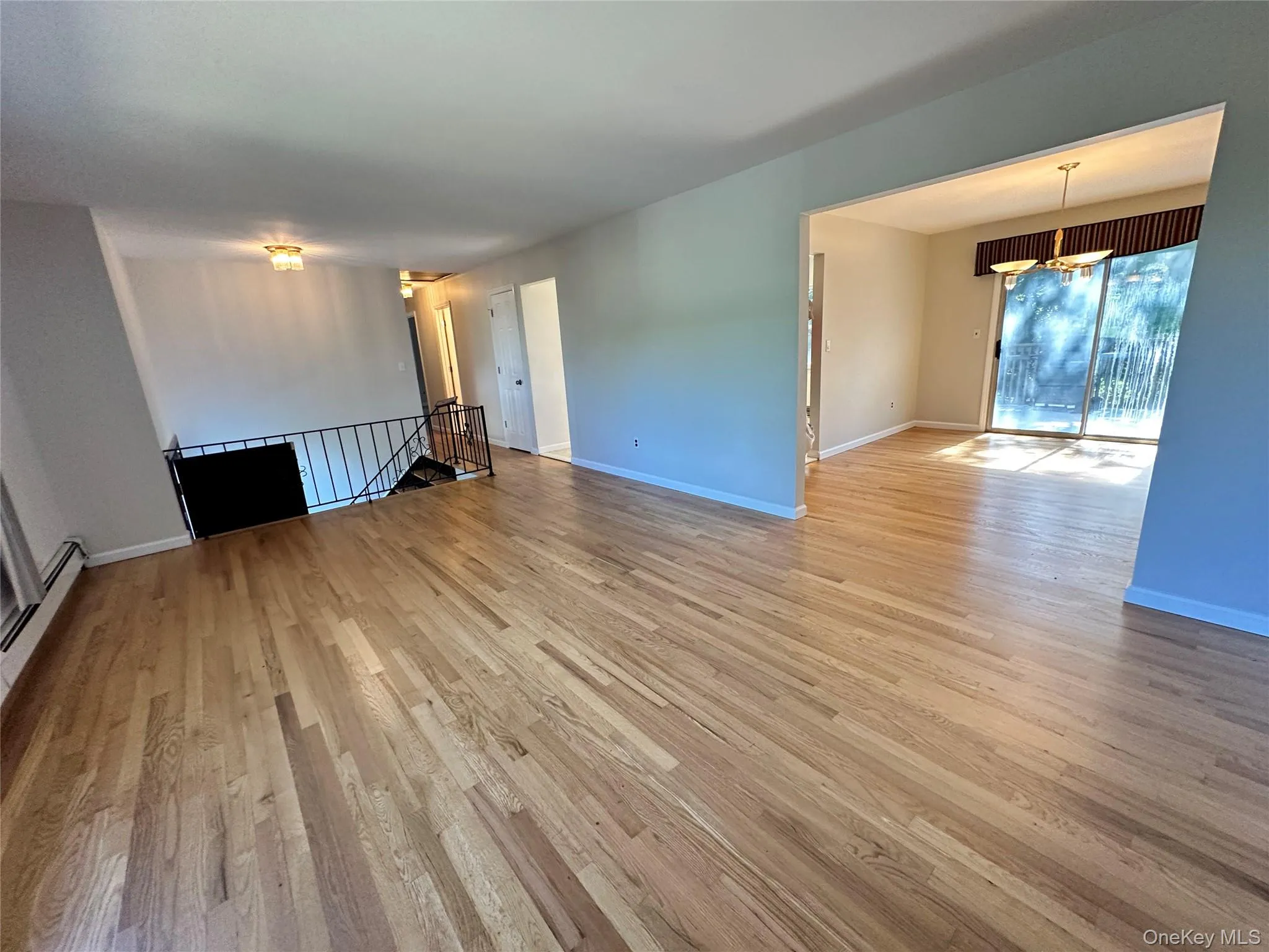 Unfurnished living room with light wood-style floors and baseboards Unfurnished living room with light wood-style floors and baseboards