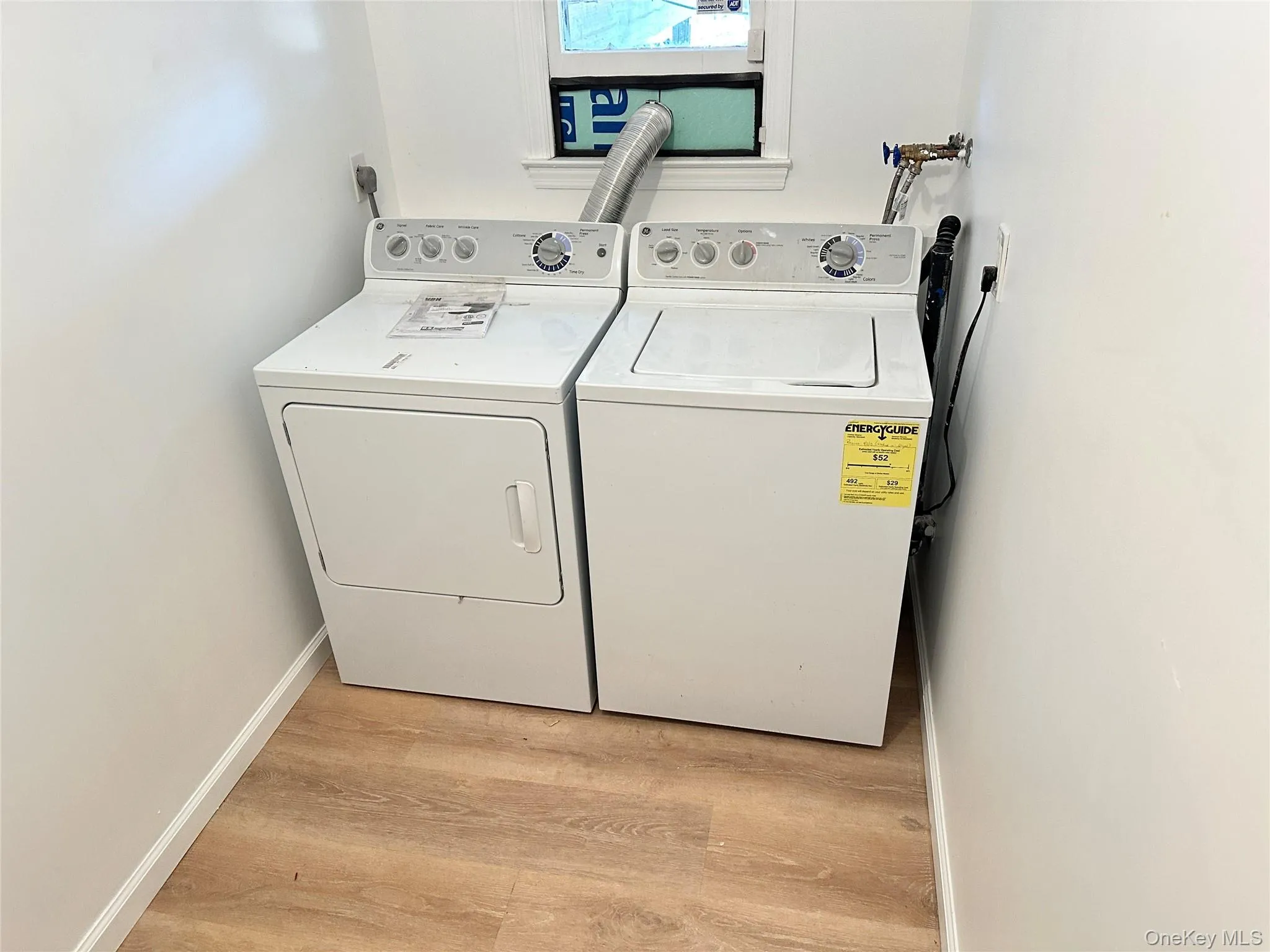 Laundry room featuring washing machine and dryer and light wood-style floors Laundry room featuring washing machine and dryer and light wood-style floors