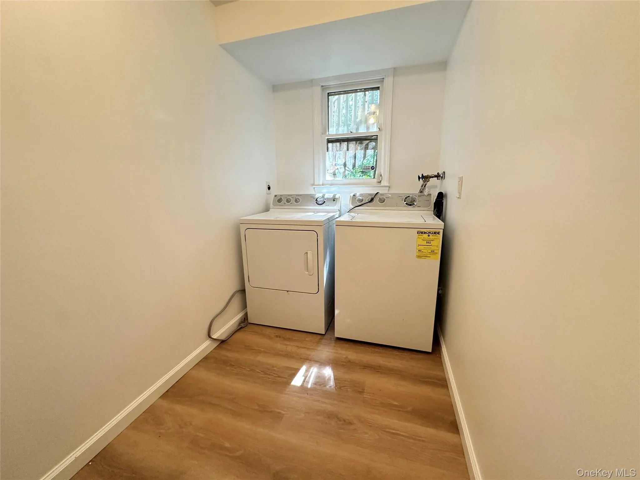 Laundry room featuring washer and dryer and light wood-type flooring Laundry room featuring washer and dryer and light wood-type flooring