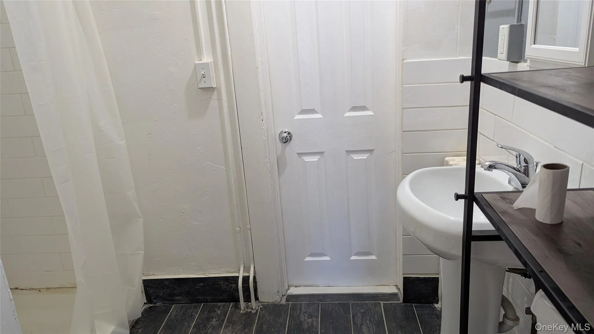 Full bath with dark wood-style floors and curtained shower Full bath with dark wood-style floors and curtained shower