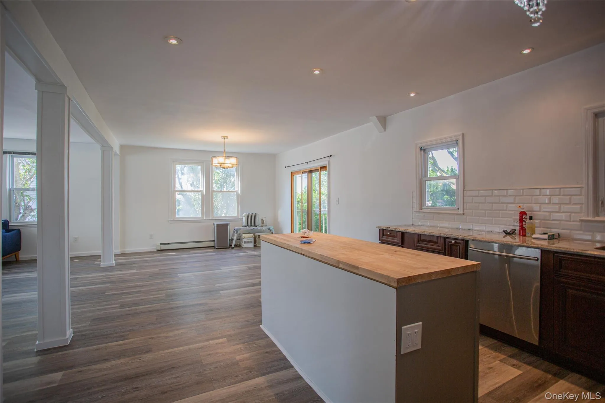 Kitchen featuring wood counters, hanging light fixtures, a center island, backsplash, and dishwasher Kitchen featuring wood counters, hanging light fixtures, a center island, backsplash, and dishwasher