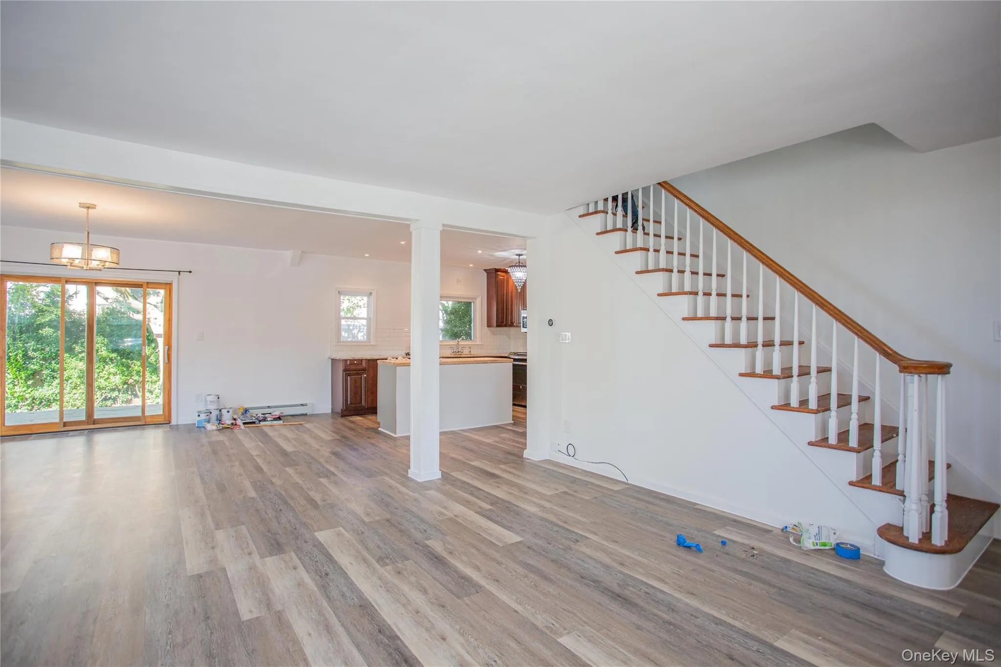 Unfurnished living room featuring light wood-type flooring, stairway, a chandelier, and recessed lighting Unfurnished living room featuring light wood-type flooring, stairway, a chandelier, and recessed lighting