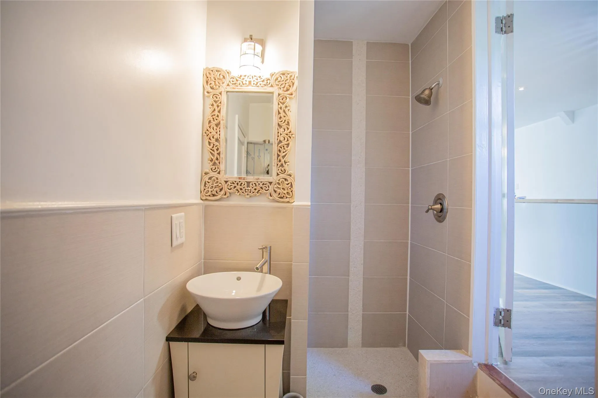 Full bathroom with a shower stall, tile walls, and vanity Full bathroom with a shower stall, tile walls, and vanity