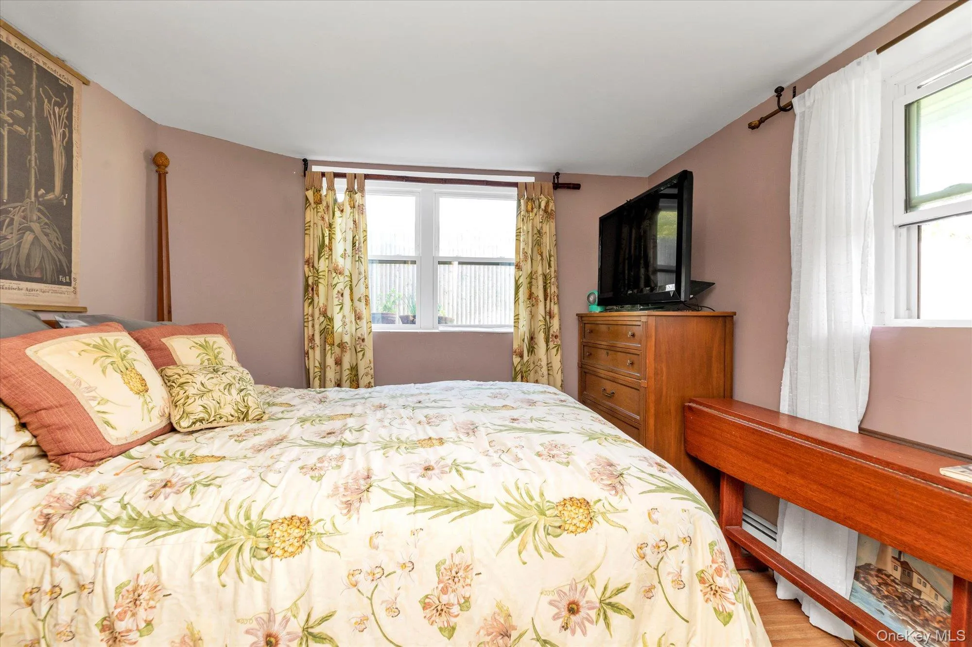 Bedroom featuring multiple windows and light wood-style floors Bedroom featuring multiple windows and light wood-style floors