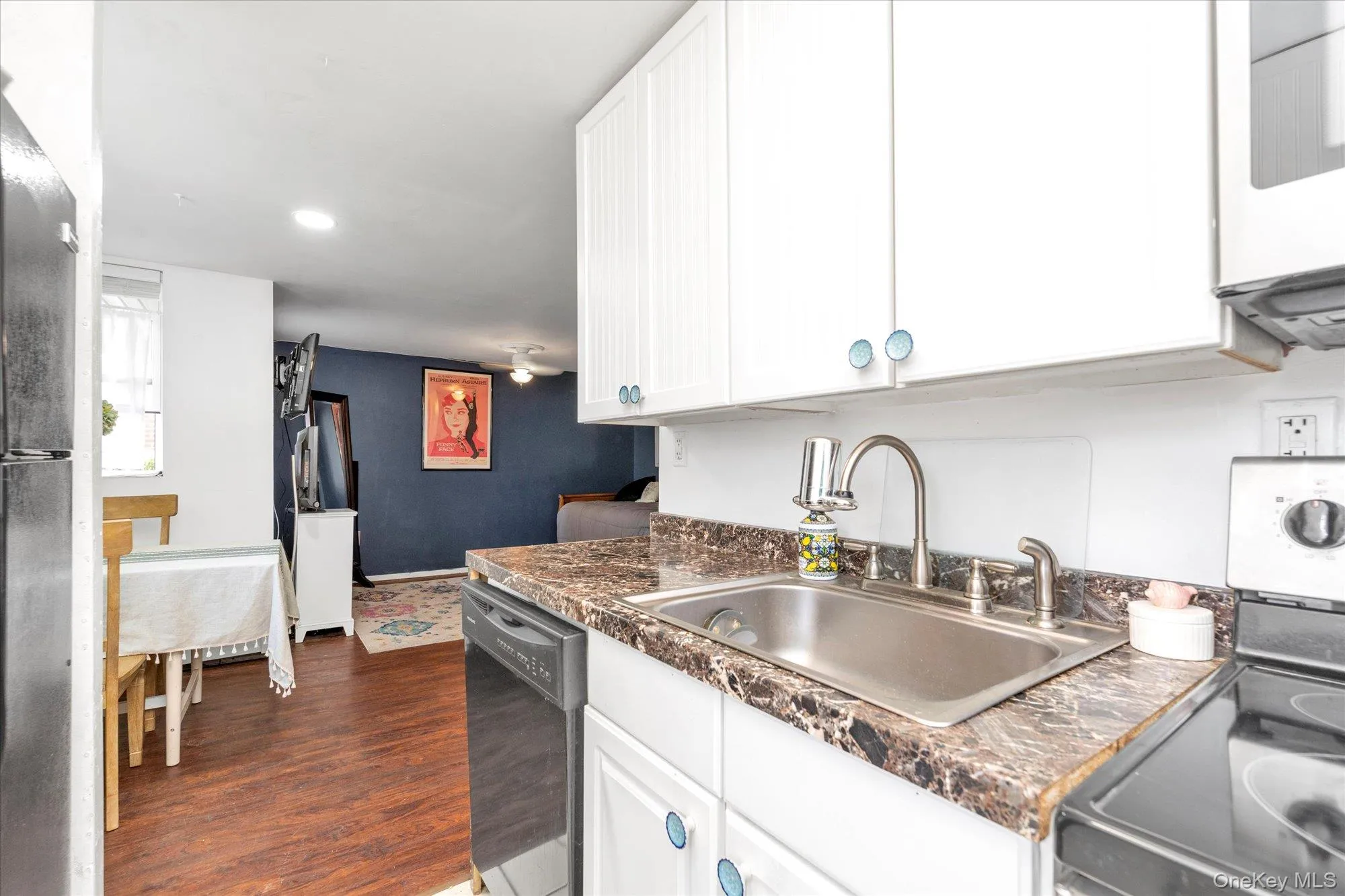 Kitchen featuring stainless steel electric range oven, dark countertops, white cabinets, dark wood finished floors, and recessed lighting Kitchen featuring stainless steel electric range oven, dark countertops, white cabinets, dark wood finished floors, and recessed lighting