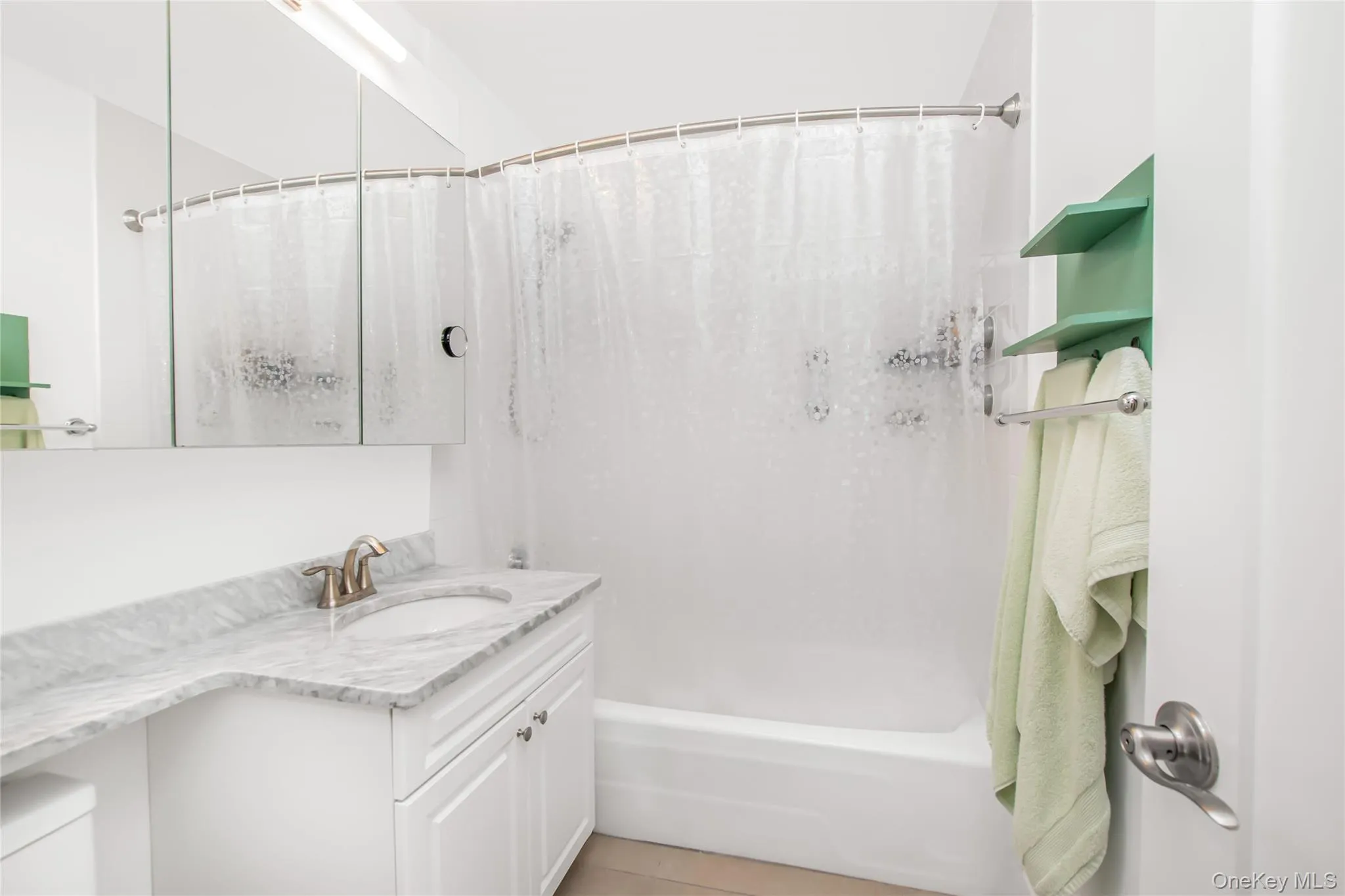 Full bath featuring shower / bath combo, vanity, and light tile patterned floors Full bath featuring shower / bath combo, vanity, and light tile patterned floors