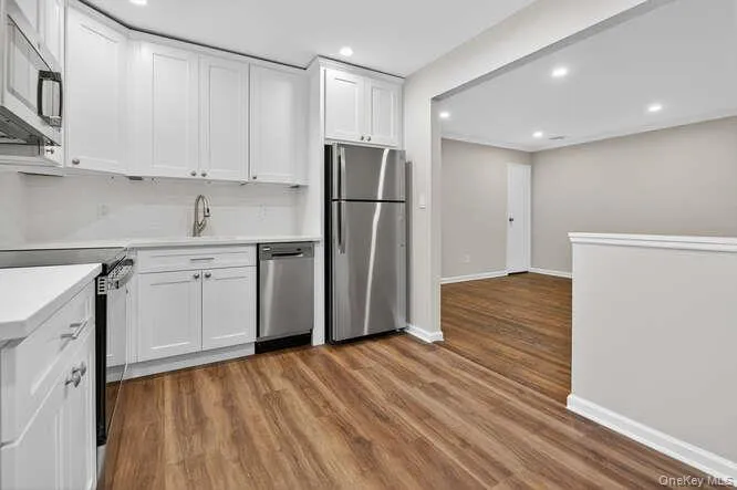 Kitchen featuring white cabinets, appliances with stainless steel finishes, light wood-style flooring, and recessed lighting Kitchen featuring white cabinets, appliances with stainless steel finishes, light wood-style flooring, and recessed lighting