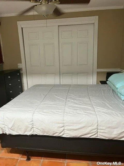 Bedroom with ornamental molding, a closet, and a ceiling fan Bedroom with ornamental molding, a closet, and a ceiling fan