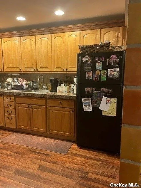 Kitchen featuring freestanding refrigerator, dark wood finished floors, brown cabinetry, and recessed lighting Kitchen featuring freestanding refrigerator, dark wood finished floors, brown cabinetry, and recessed lighting