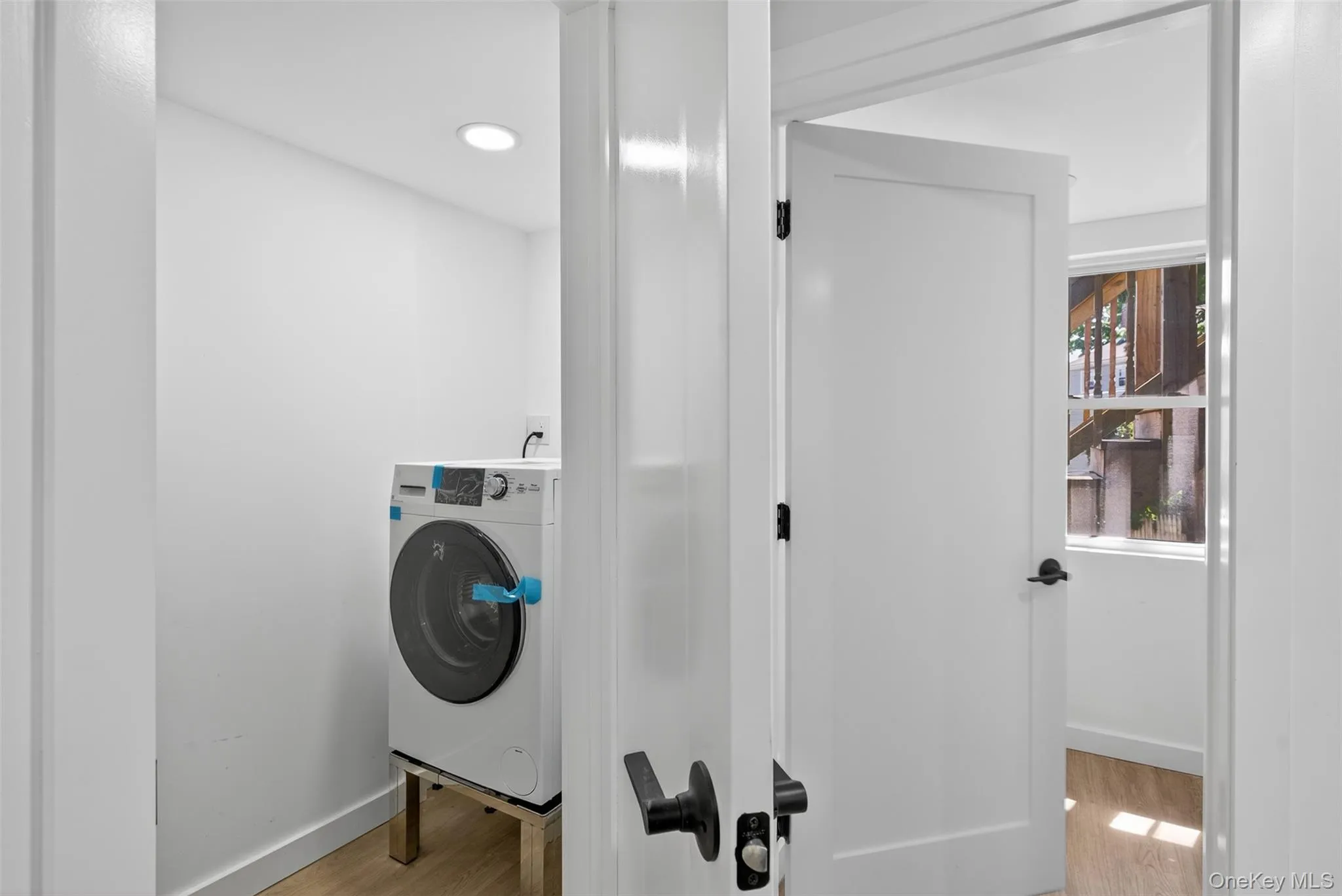 Washroom featuring washer / clothes dryer and light wood-style flooring Washroom featuring washer / clothes dryer and light wood-style flooring