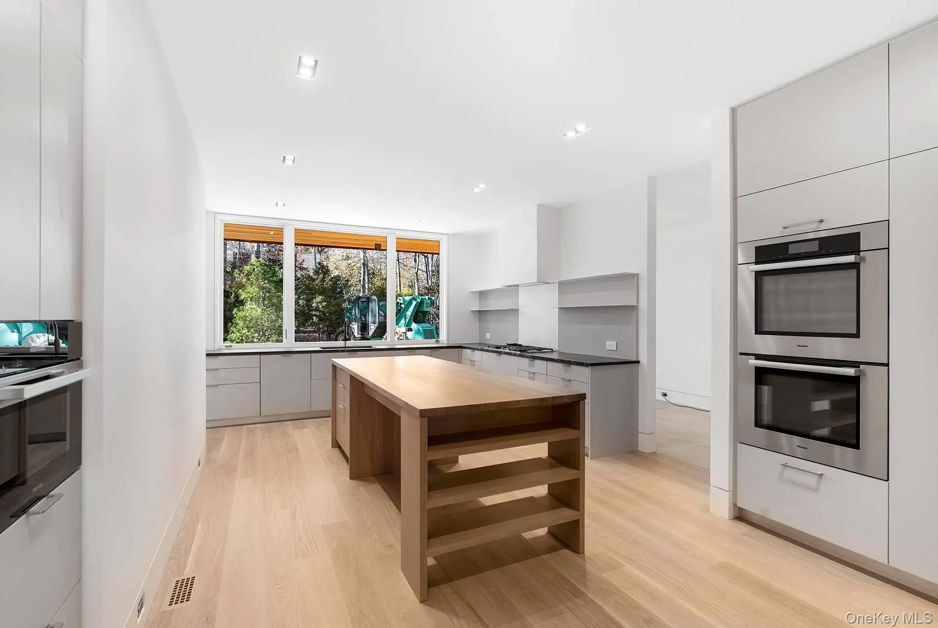 Kitchen featuring stainless steel appliances, modern cabinets, a center island, butcher block countertops, and recessed lighting Kitchen featuring stainless steel appliances, modern cabinets, a center island, butcher block countertops, and recessed lighting