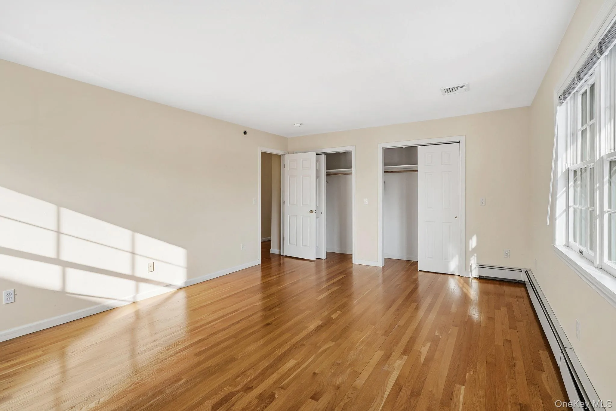 Featuring hardwood floors, his and her's closets, and ensuite bathroom Featuring hardwood floors, his and her's closets, and ensuite bathroom