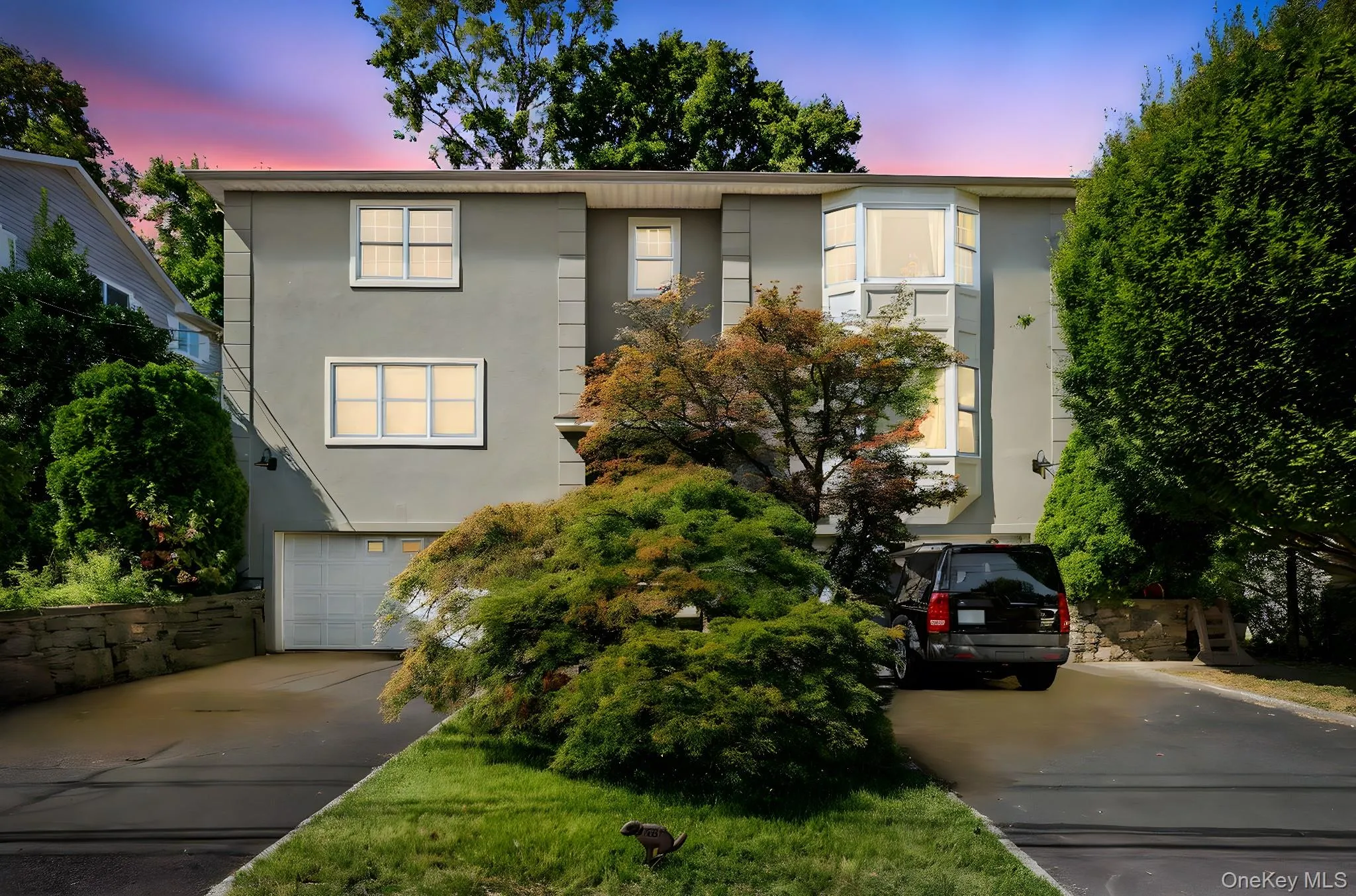 View of front of property with stucco siding, concrete driveway, and an attached garage View of front of property with stucco siding, concrete driveway, and an attached garage