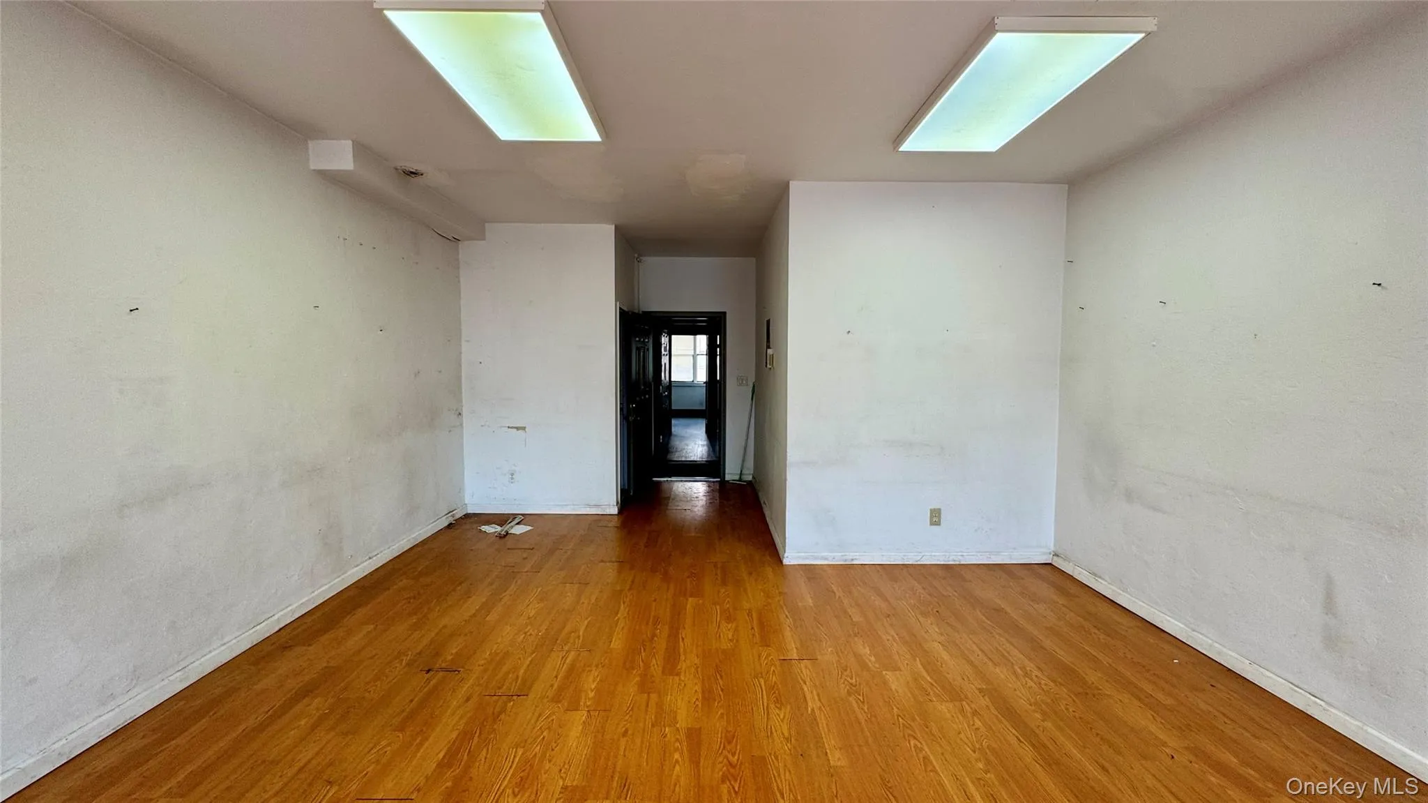 Unfurnished room with wood finished floors and baseboards Unfurnished room with wood finished floors and baseboards