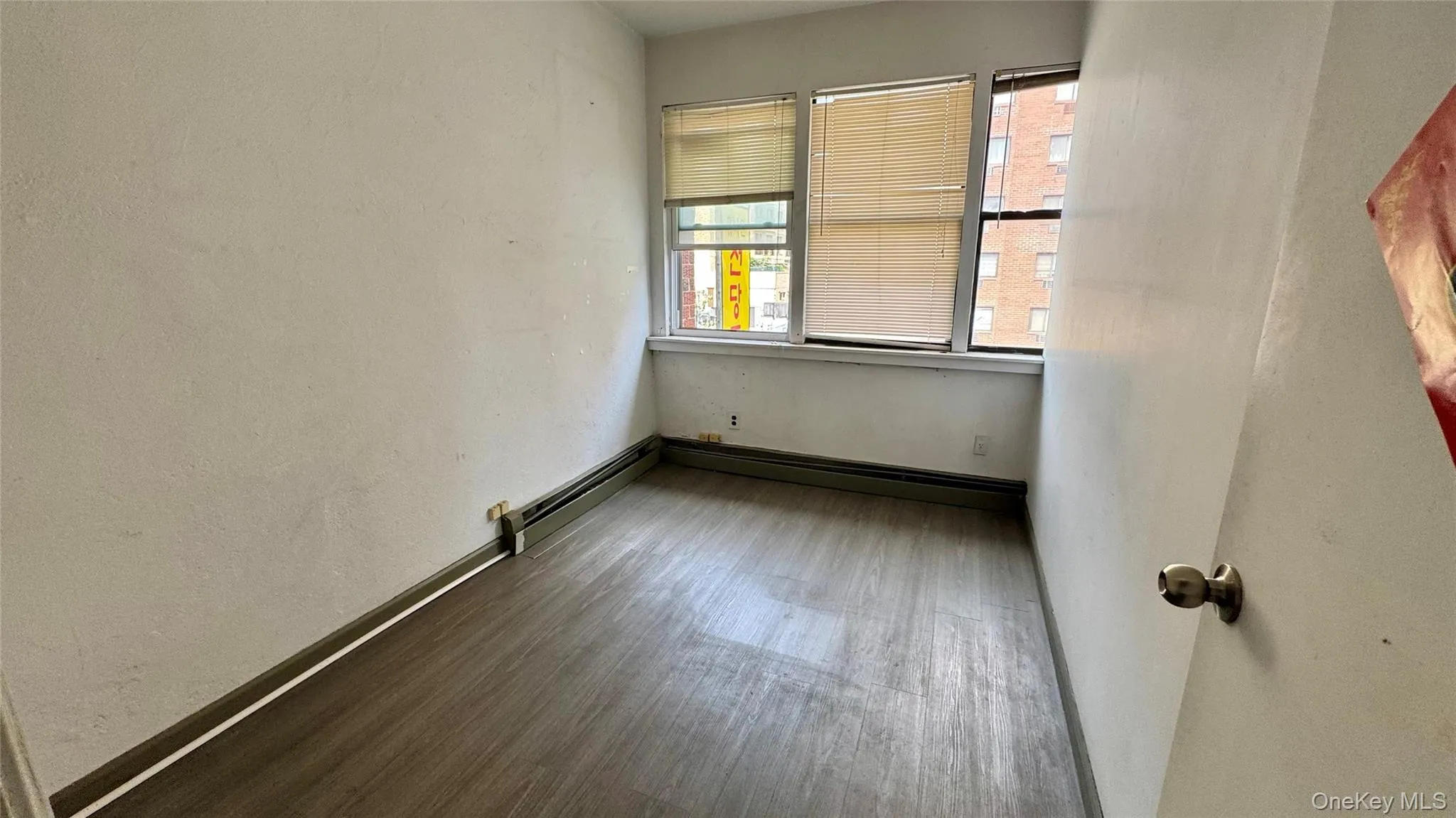 Empty room featuring a textured wall and wood finished floors Empty room featuring a textured wall and wood finished floors