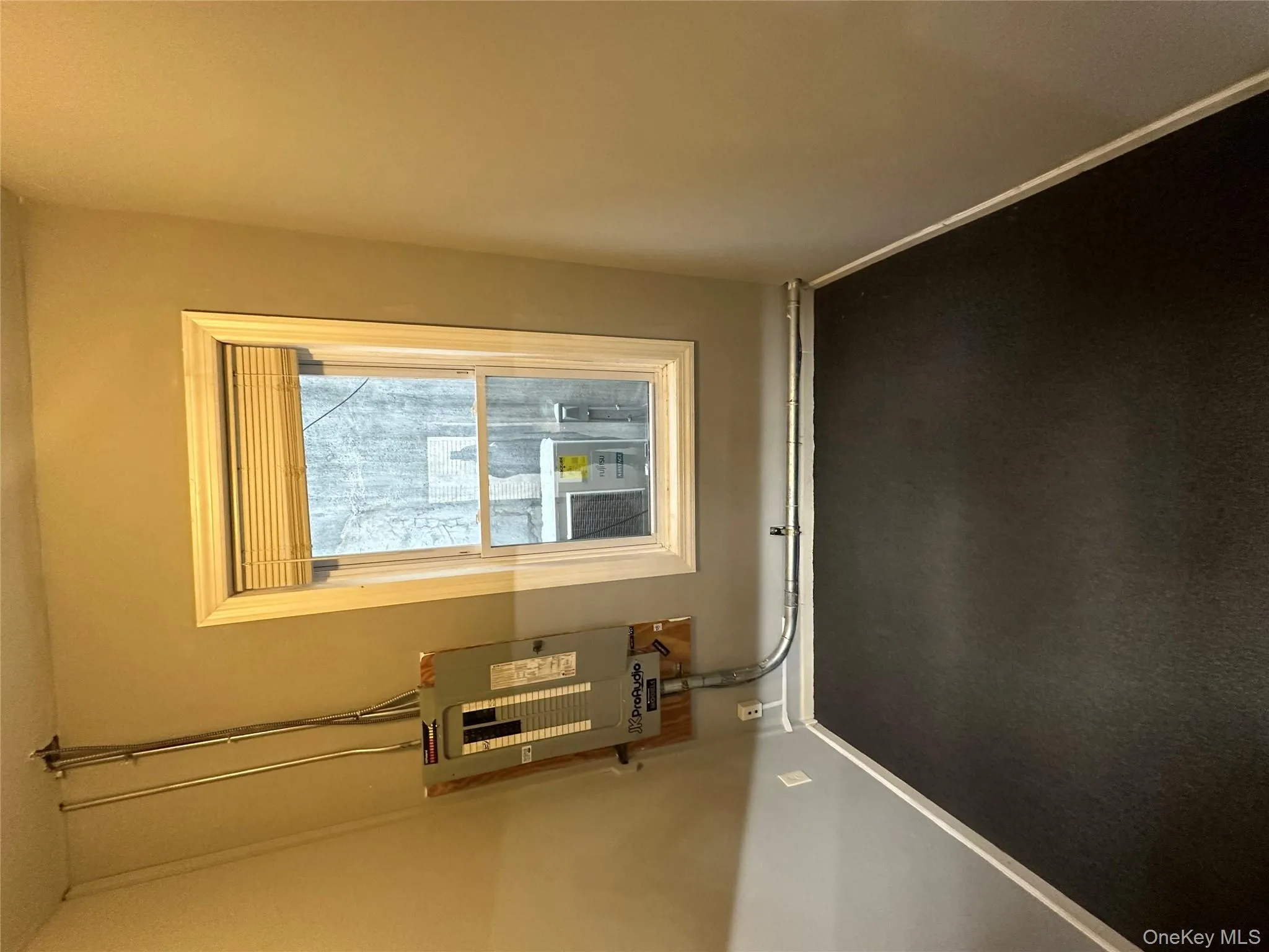 Carpeted spare room with baseboards and electric panel Carpeted spare room with baseboards and electric panel