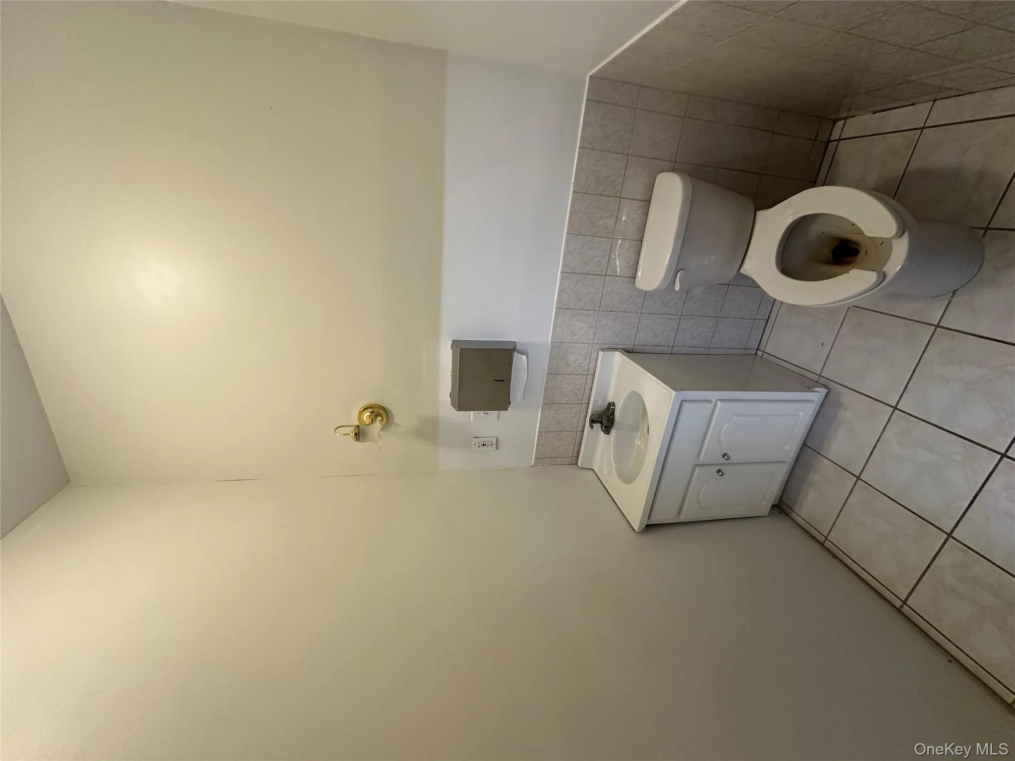 Bathroom with tile walls, light tile patterned floors, vanity, and wainscoting Bathroom with tile walls, light tile patterned floors, vanity, and wainscoting