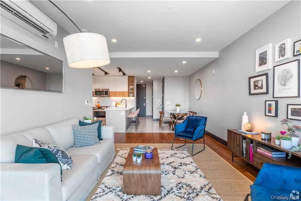 Living room featuring hardwood / wood-style flooring, sink, and a wall mounted AC Living room featuring hardwood / wood-style flooring, sink, and a wall mounted AC