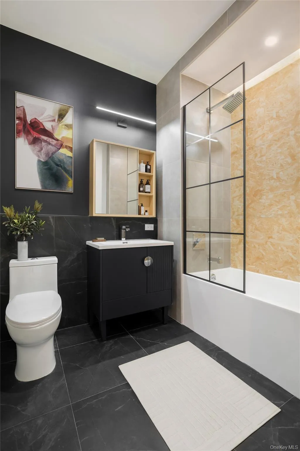 Full bathroom featuring tile walls, vanity, toilet, and bathing tub / shower combination Full bathroom featuring tile walls, vanity, toilet, and bathing tub / shower combination
