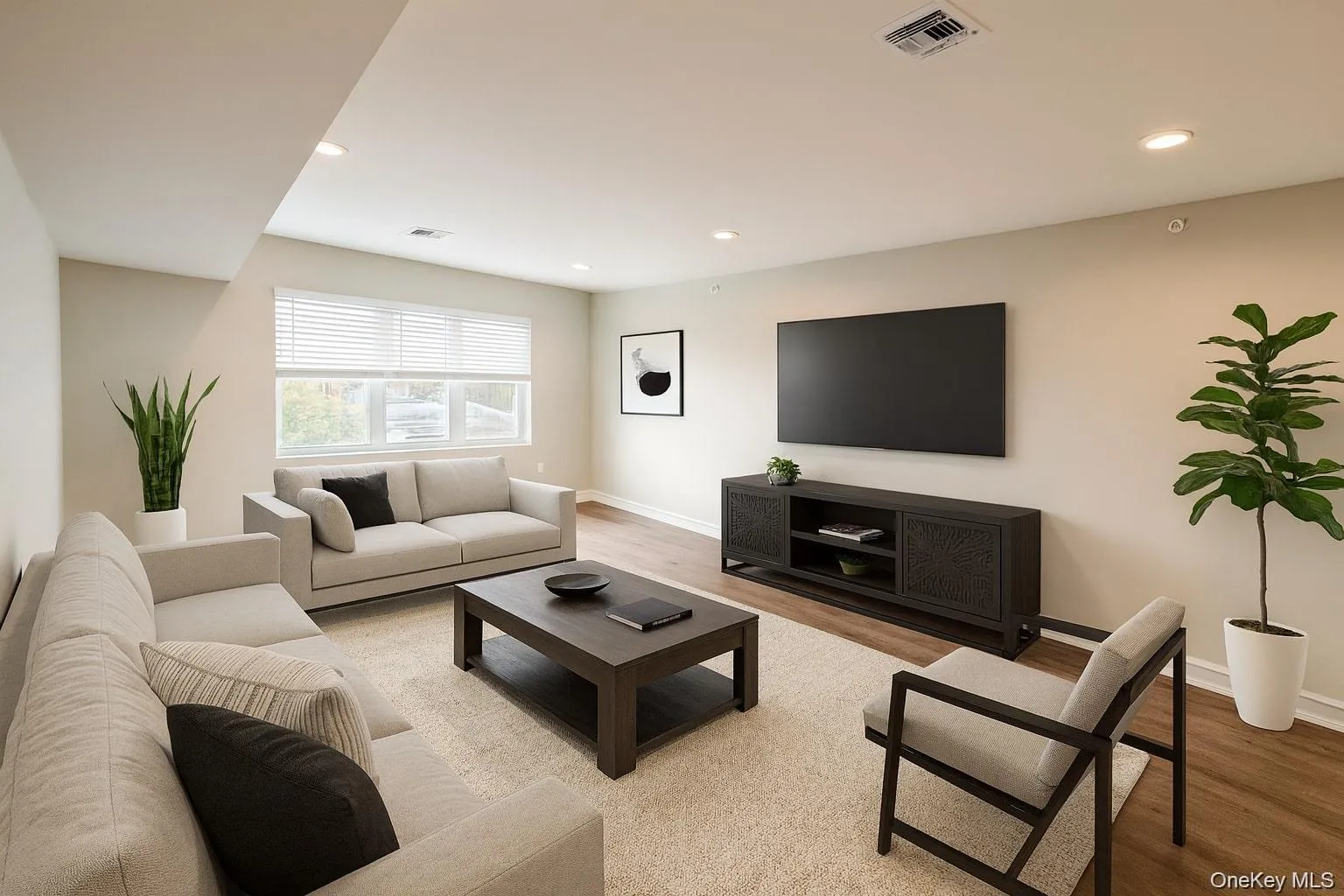 Living area with light wood-style floors and recessed lighting Living area with light wood-style floors and recessed lighting