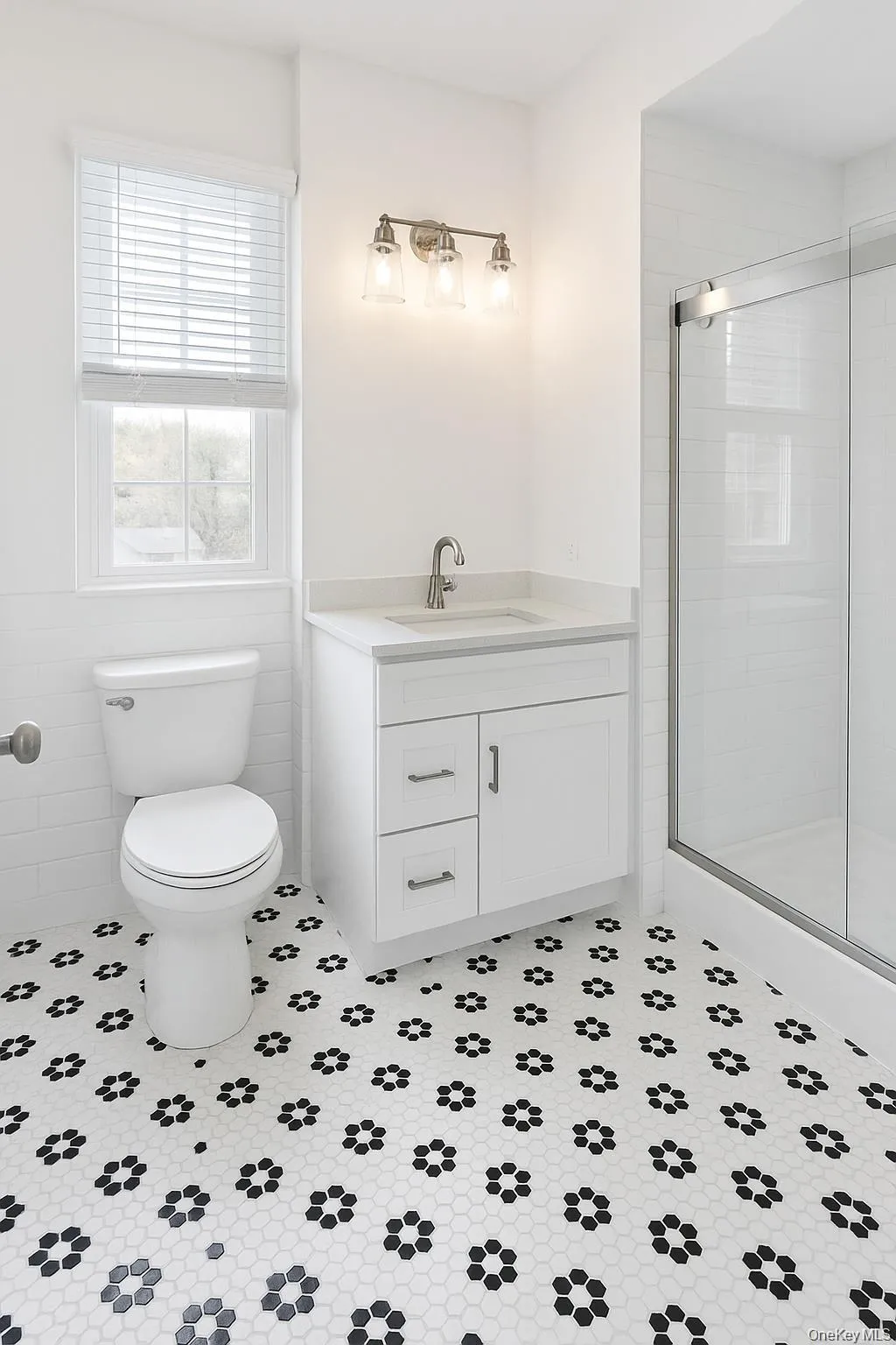 Bathroom featuring vanity, a stall shower, tile walls, and a wainscoted wall Bathroom featuring vanity, a stall shower, tile walls, and a wainscoted wall