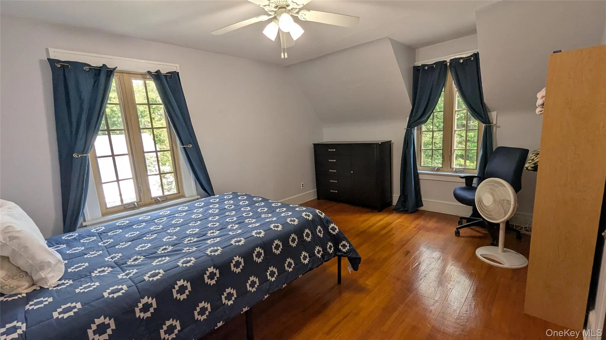 Bedroom featuring wood finished floors, ceiling fan, and vaulted ceiling Bedroom featuring wood finished floors, ceiling fan, and vaulted ceiling