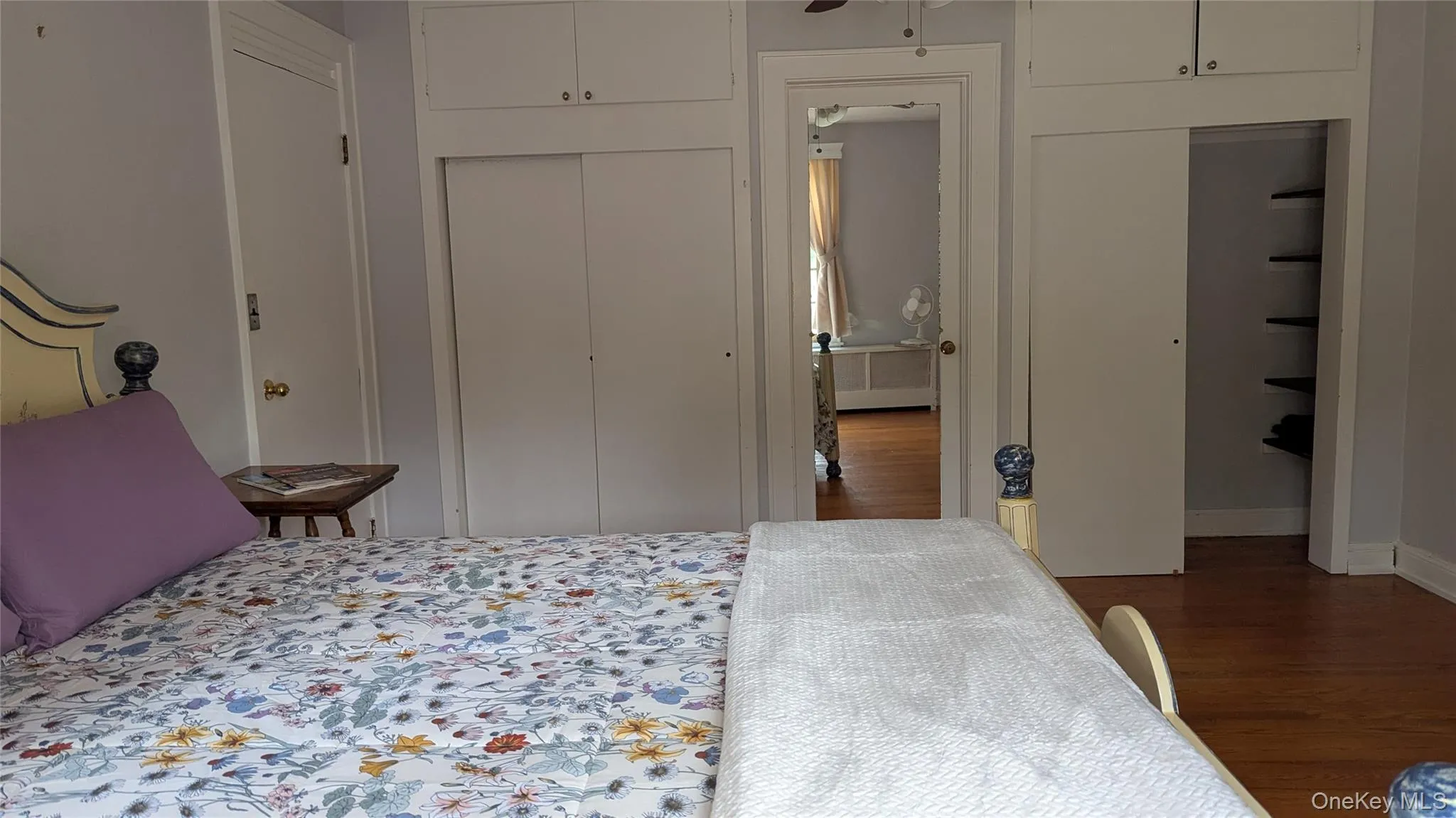 Bedroom featuring dark wood-style floors and two closets Bedroom featuring dark wood-style floors and two closets