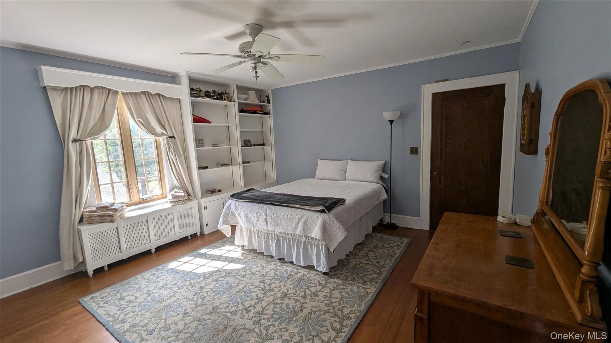 Bedroom featuring ornamental molding, wood finished floors, and a ceiling fan Bedroom featuring ornamental molding, wood finished floors, and a ceiling fan