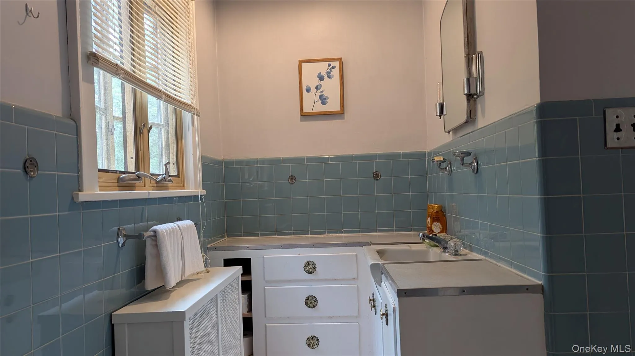 Bathroom with tile walls, a wainscoted wall, and radiator heating unit Bathroom with tile walls, a wainscoted wall, and radiator heating unit