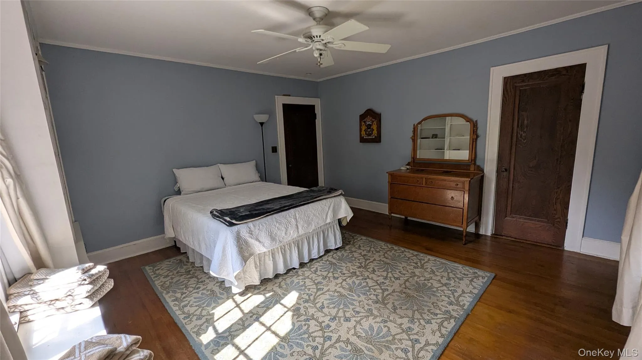 Bedroom featuring crown molding, dark wood finished floors, ceiling fan, and a closet Bedroom featuring crown molding, dark wood finished floors, ceiling fan, and a closet