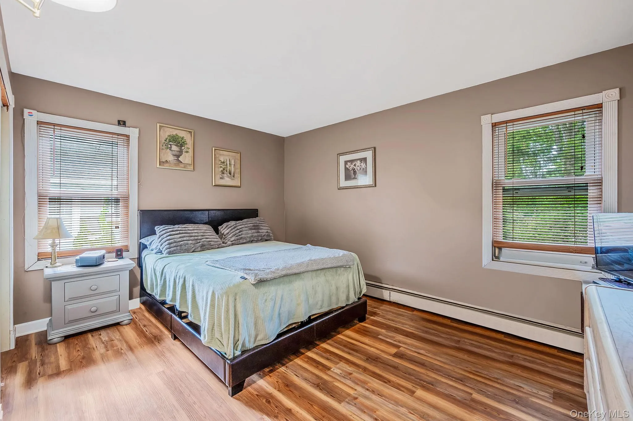 Bedroom with a baseboard heating unit and wood finished floors Bedroom with a baseboard heating unit and wood finished floors
