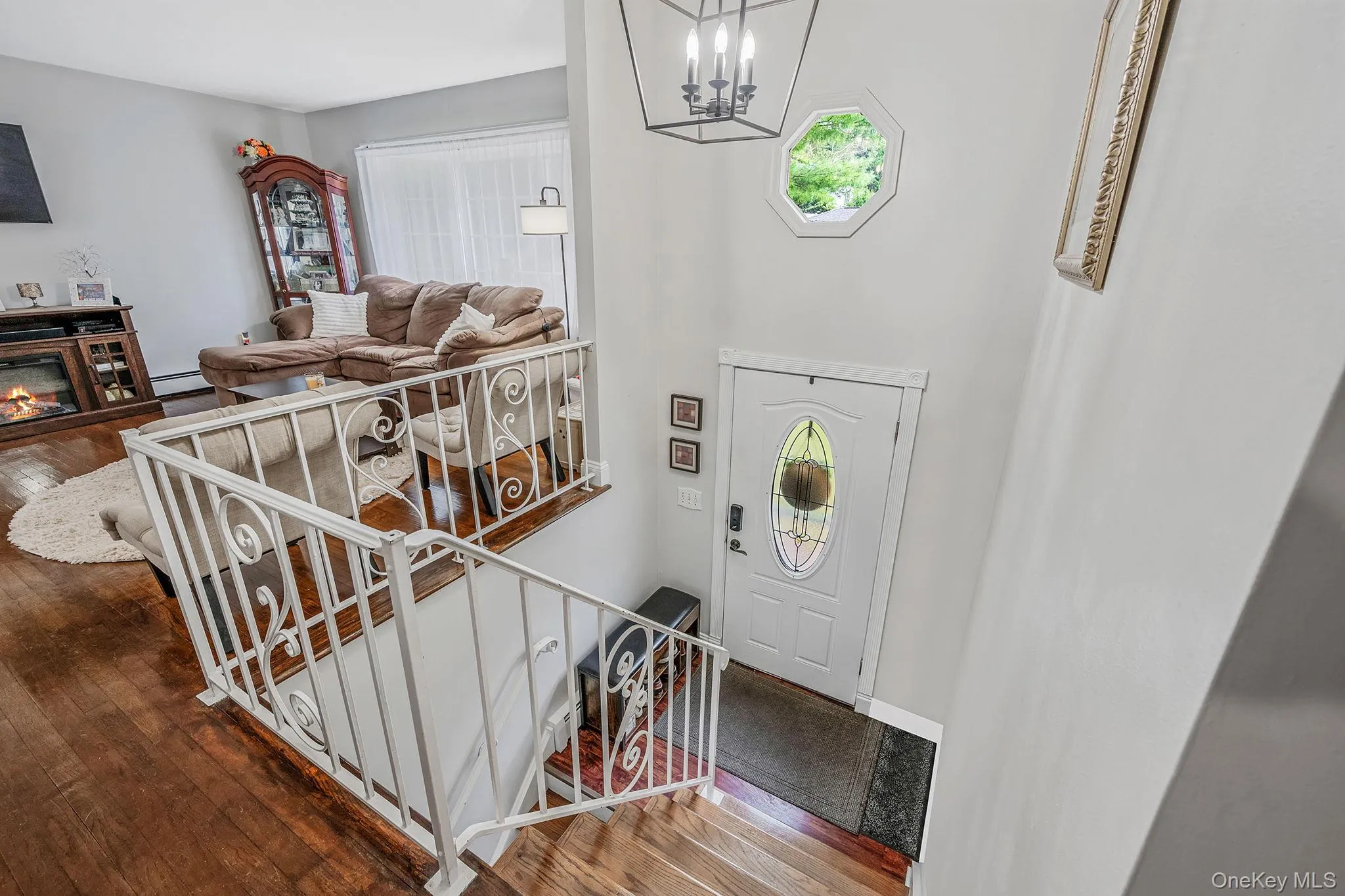 Entryway with dark wood-style floors, stairway, healthy amount of natural light, and a glass covered fireplace Entryway with dark wood-style floors, stairway, healthy amount of natural light, and a glass covered fireplace