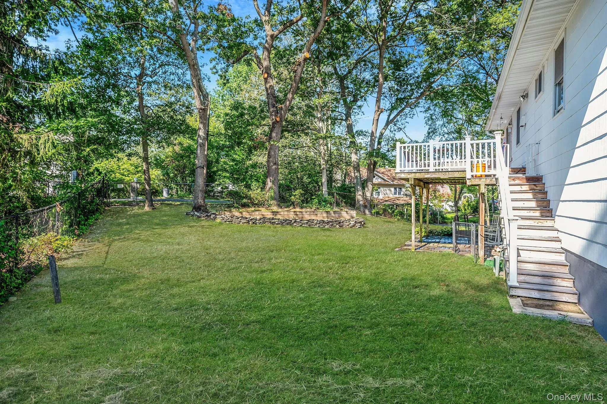 Fenced backyard with stairway and a wooden deck Fenced backyard with stairway and a wooden deck