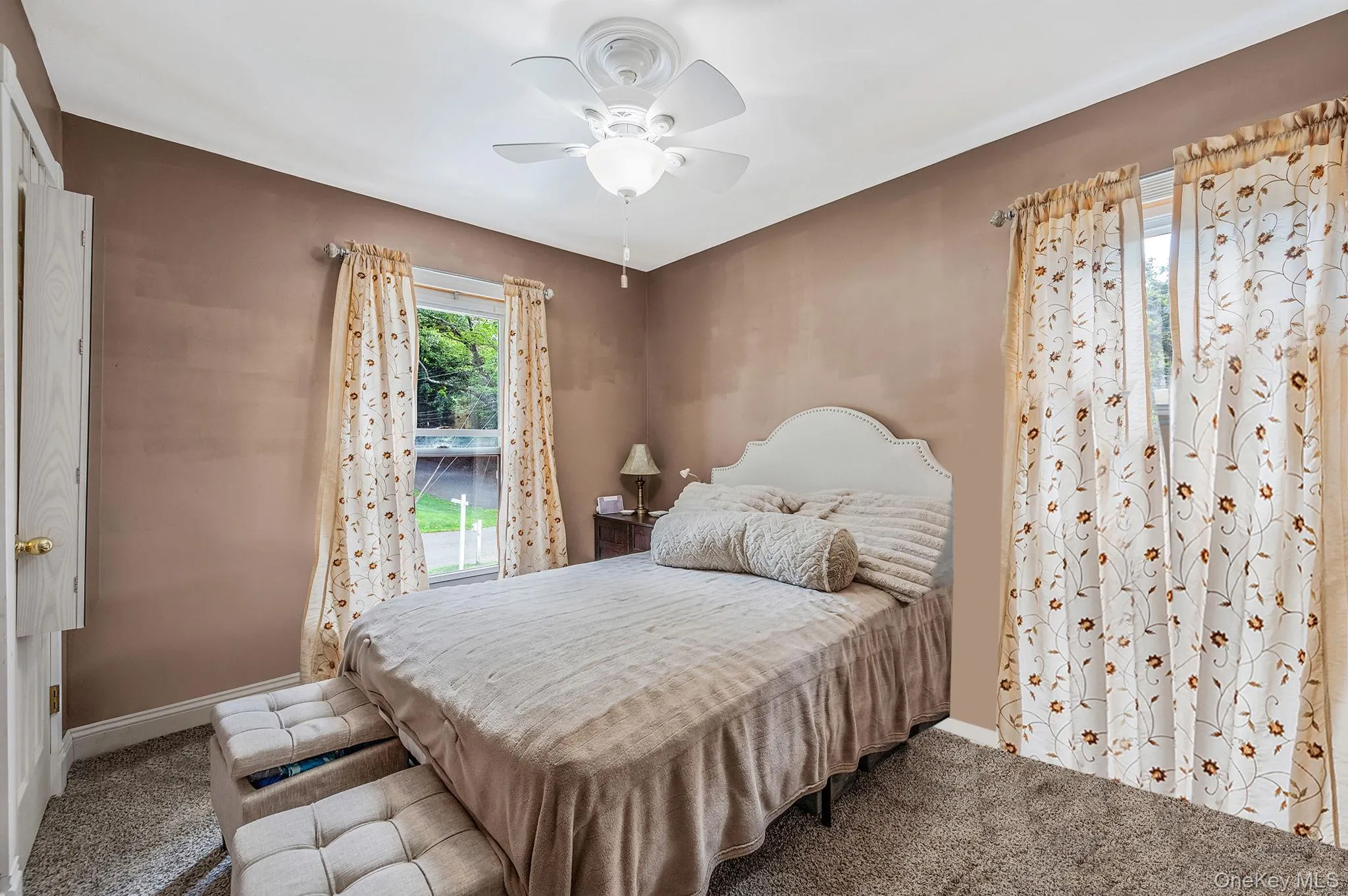 Carpeted bedroom with a ceiling fan and baseboards Carpeted bedroom with a ceiling fan and baseboards