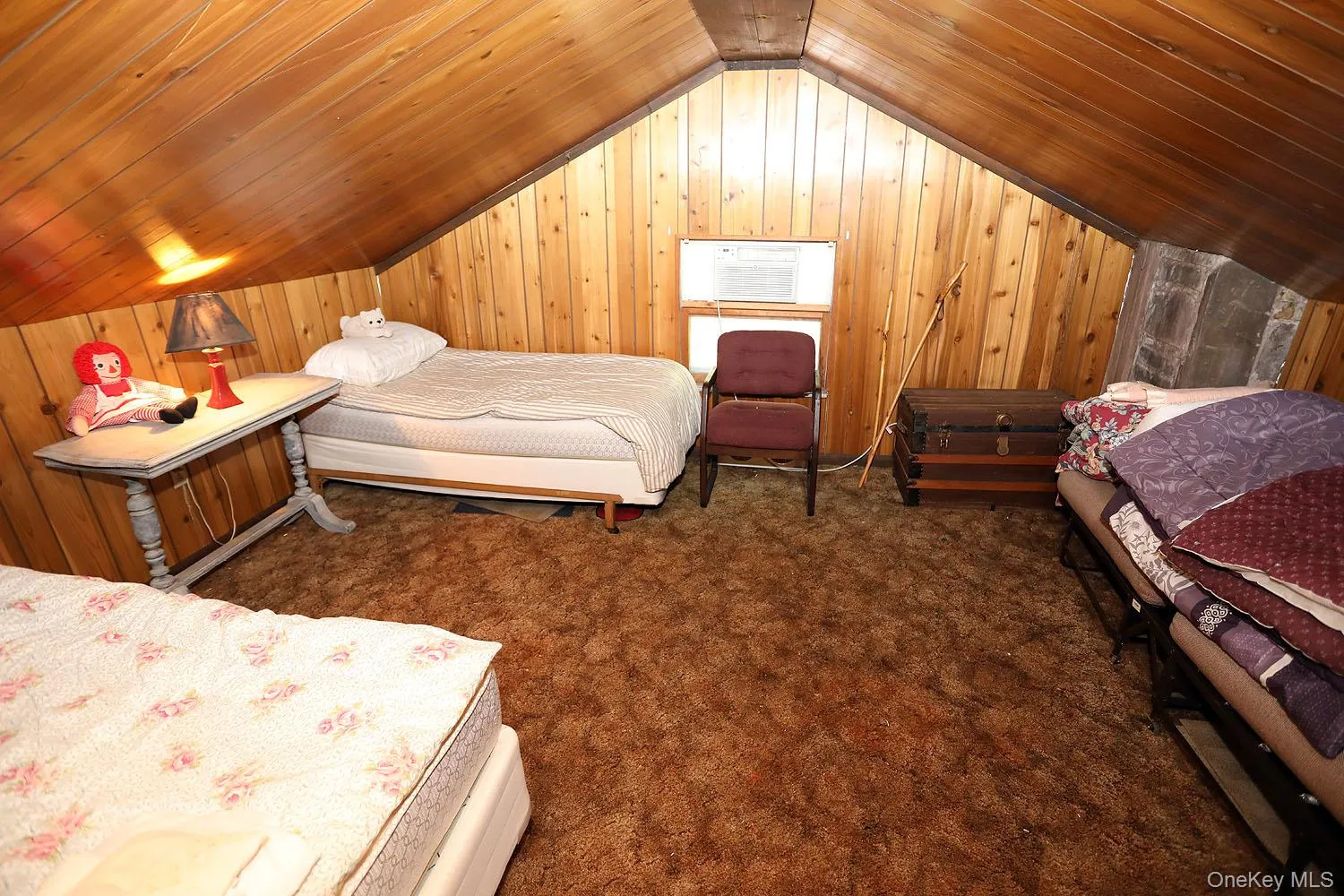 Bedroom featuring wood walls, lofted ceiling, dark carpet, and wooden ceiling Bedroom featuring wood walls, lofted ceiling, dark carpet, and wooden ceiling