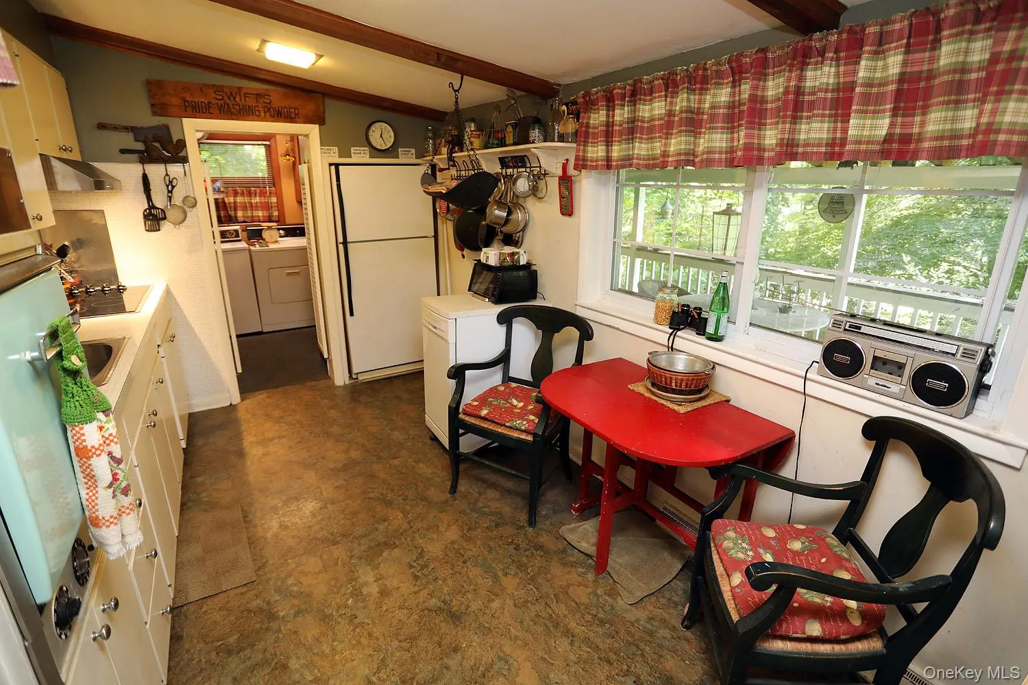 Dining room with plenty of natural light, separate washer and dryer, and dark floors Dining room with plenty of natural light, separate washer and dryer, and dark floors