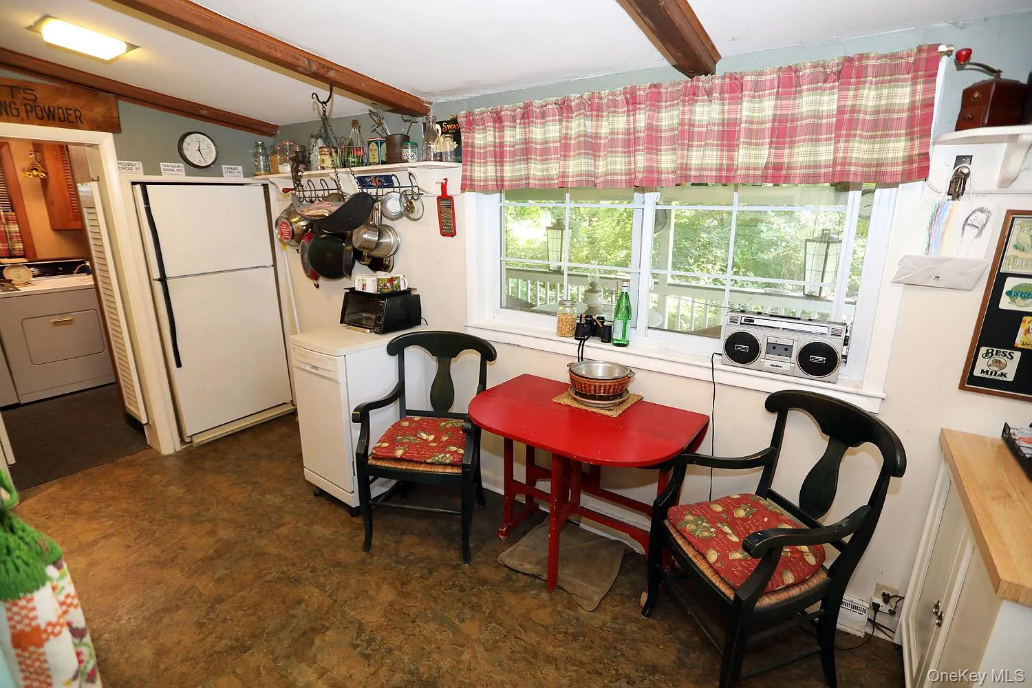 Dining area with washer / clothes dryer, beamed ceiling, and dark flooring Dining area with washer / clothes dryer, beamed ceiling, and dark flooring