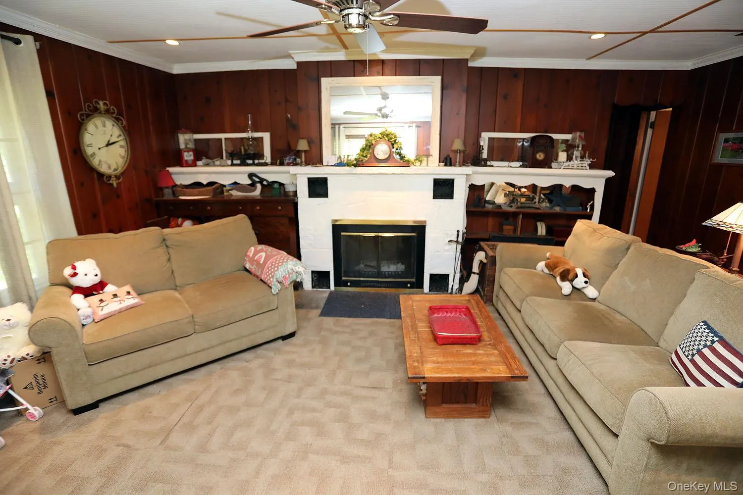 Living area featuring ornamental molding, a glass covered fireplace, wood walls, recessed lighting, and carpet flooring Living area featuring ornamental molding, a glass covered fireplace, wood walls, recessed lighting, and carpet flooring
