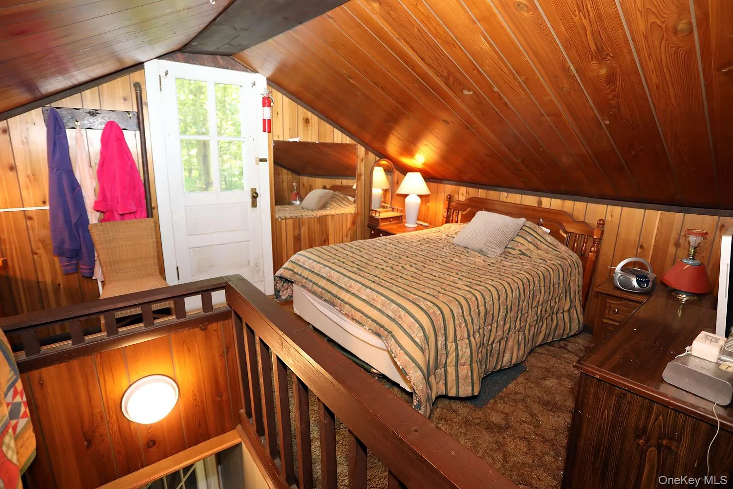 Bedroom featuring wood walls, vaulted ceiling, and wood ceiling Bedroom featuring wood walls, vaulted ceiling, and wood ceiling