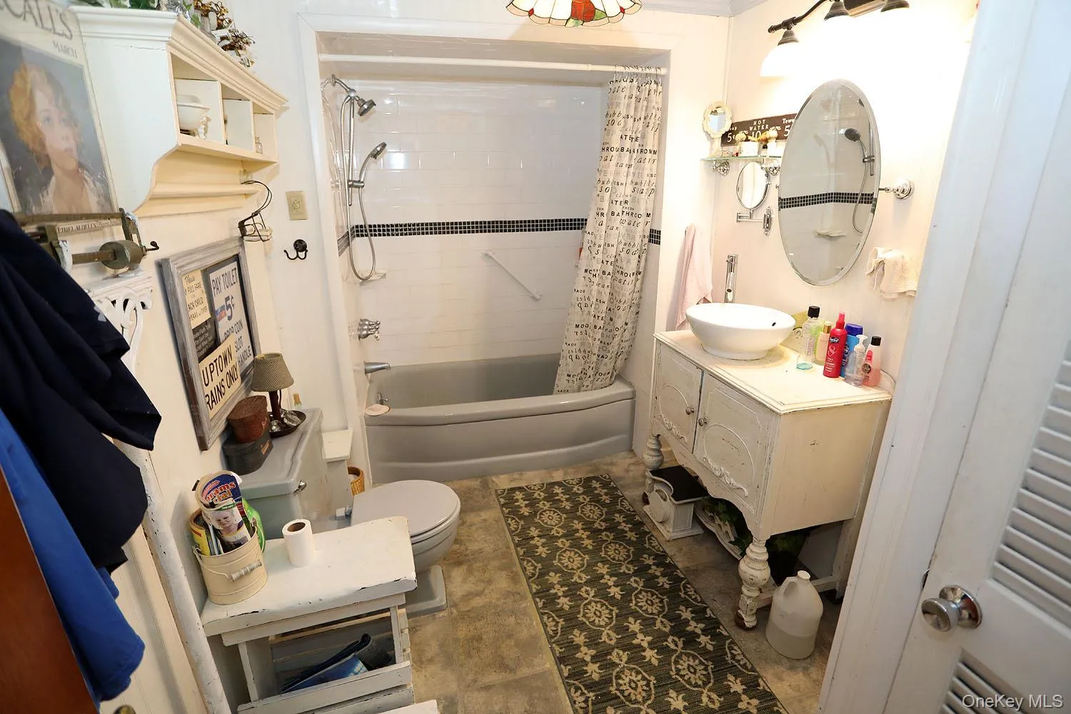 Bathroom featuring shower / bath combination with curtain, vanity, and light tile patterned floors Bathroom featuring shower / bath combination with curtain, vanity, and light tile patterned floors