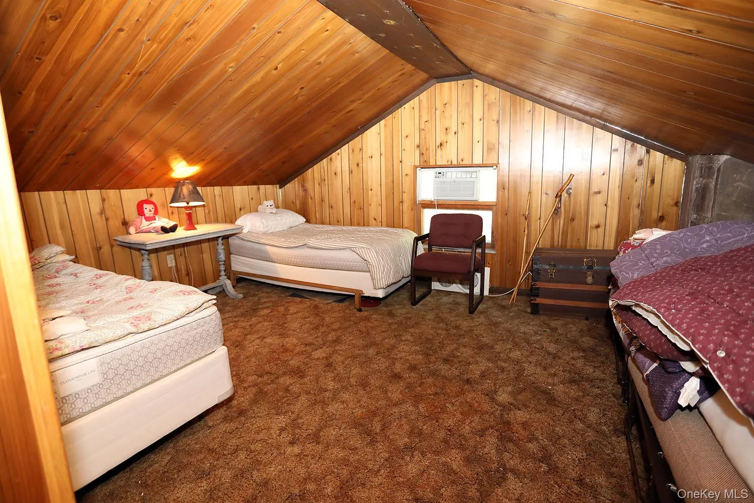 Carpeted bedroom featuring wood walls and wood ceiling Carpeted bedroom featuring wood walls and wood ceiling