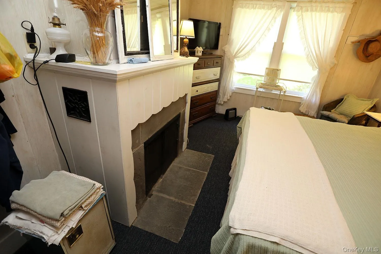 Bedroom featuring dark carpet and a fireplace with hearth Bedroom featuring dark carpet and a fireplace with hearth