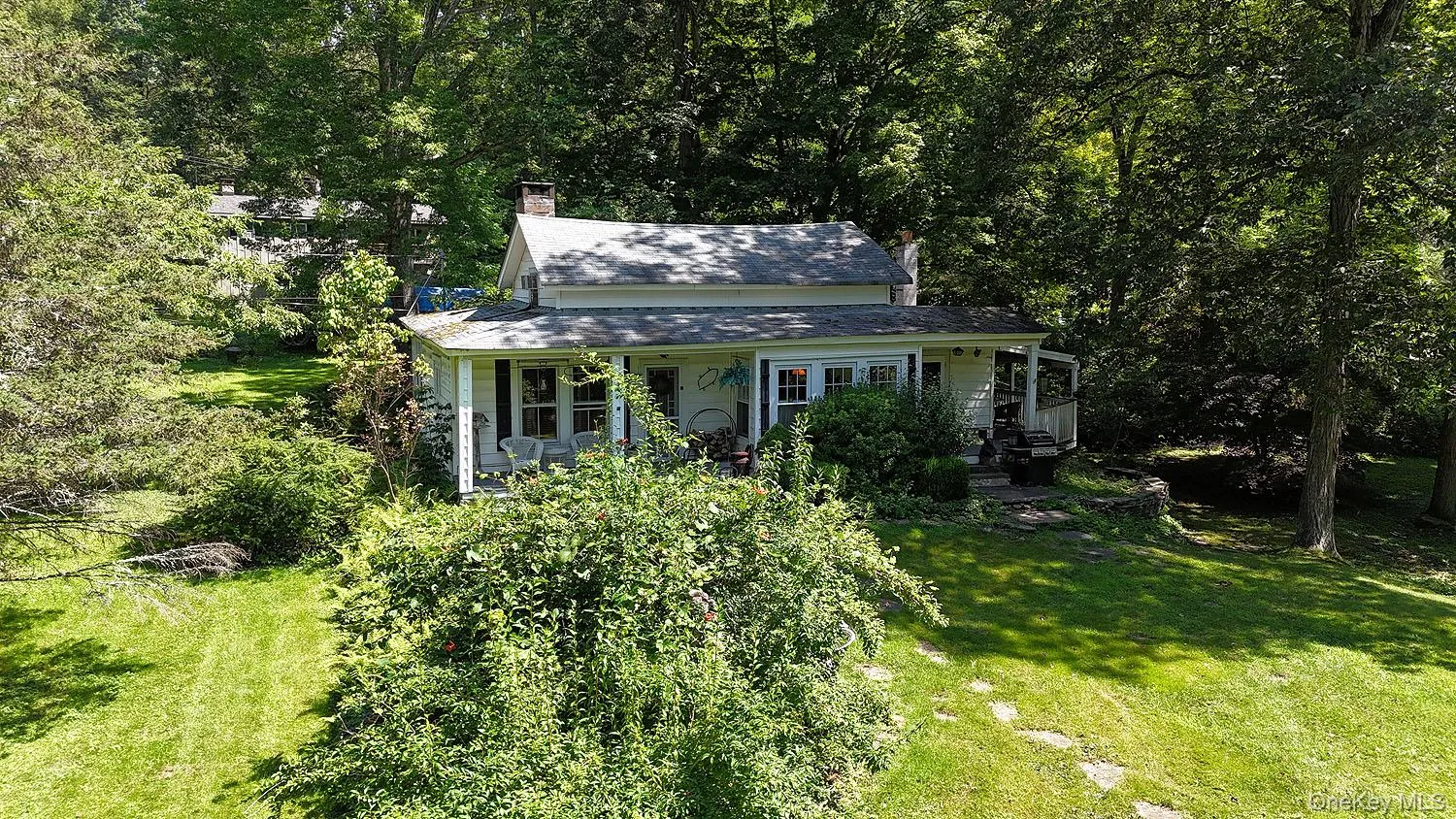 View of front of property featuring a chimney, a front yard, and covered porch View of front of property featuring a chimney, a front yard, and covered porch