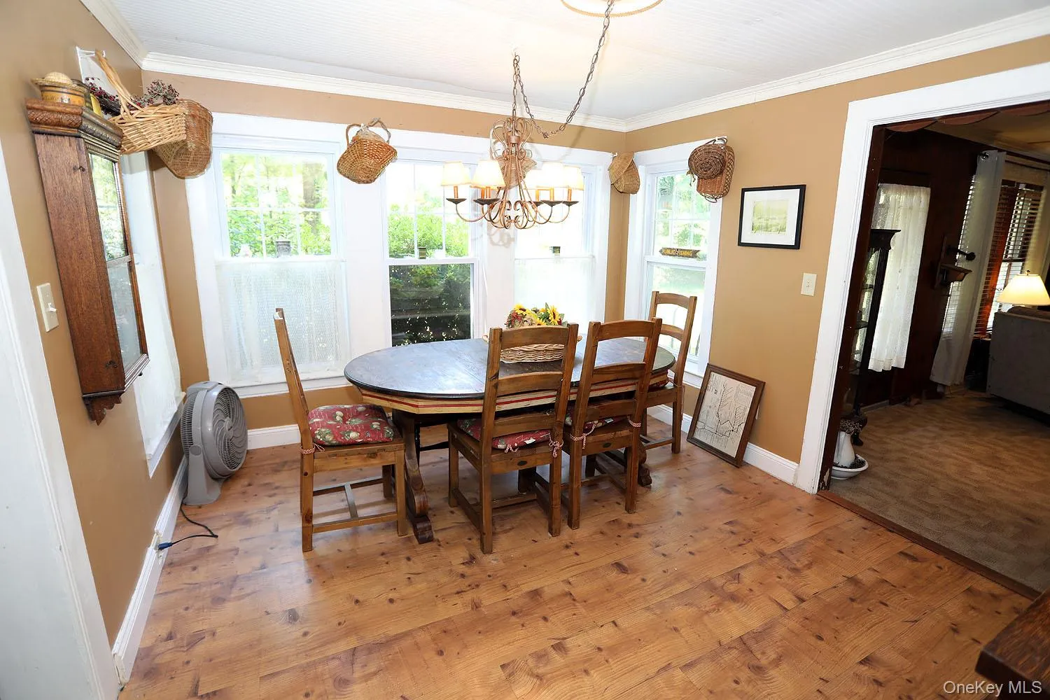Dining space featuring light wood-style floors, crown molding, and a chandelier Dining space featuring light wood-style floors, crown molding, and a chandelier