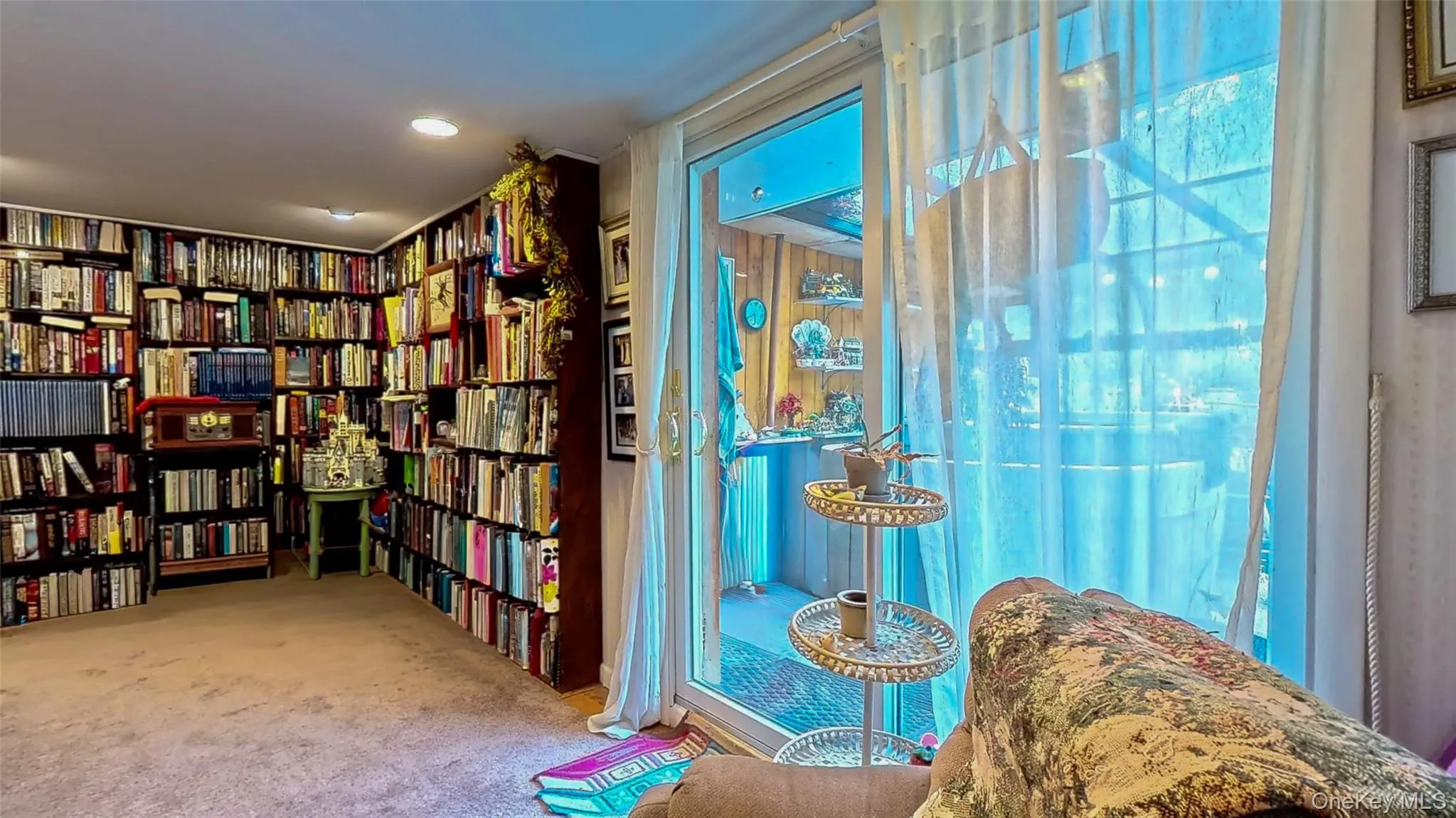 Family room with bookshelves and sliders to the sunroom Family room with bookshelves and sliders to the sunroom