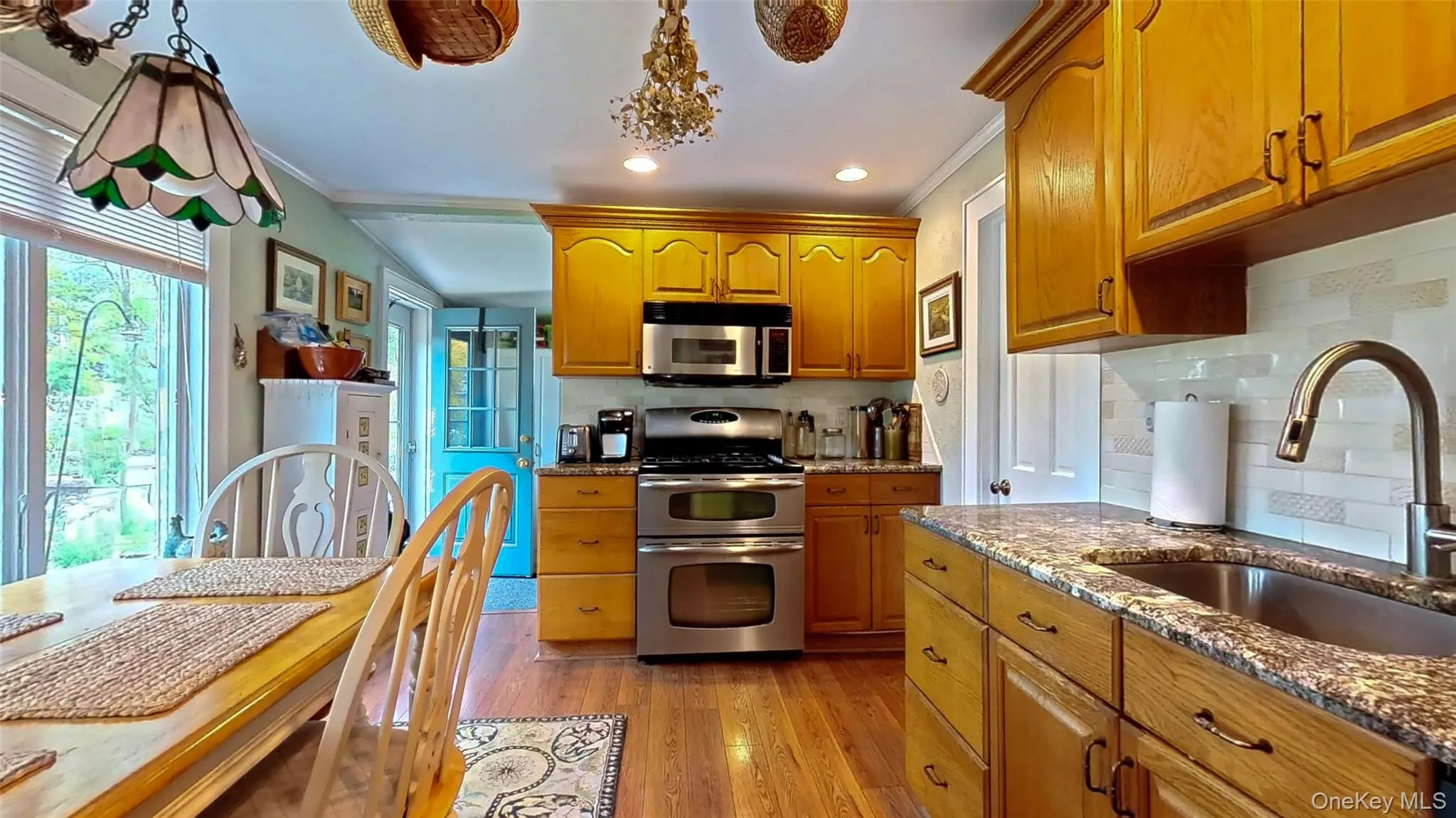Kitchen featuring granite counters, 5 burner range with double oven and microwave and tasteful backsplash Kitchen featuring granite counters, 5 burner range with double oven and microwave and tasteful backsplash