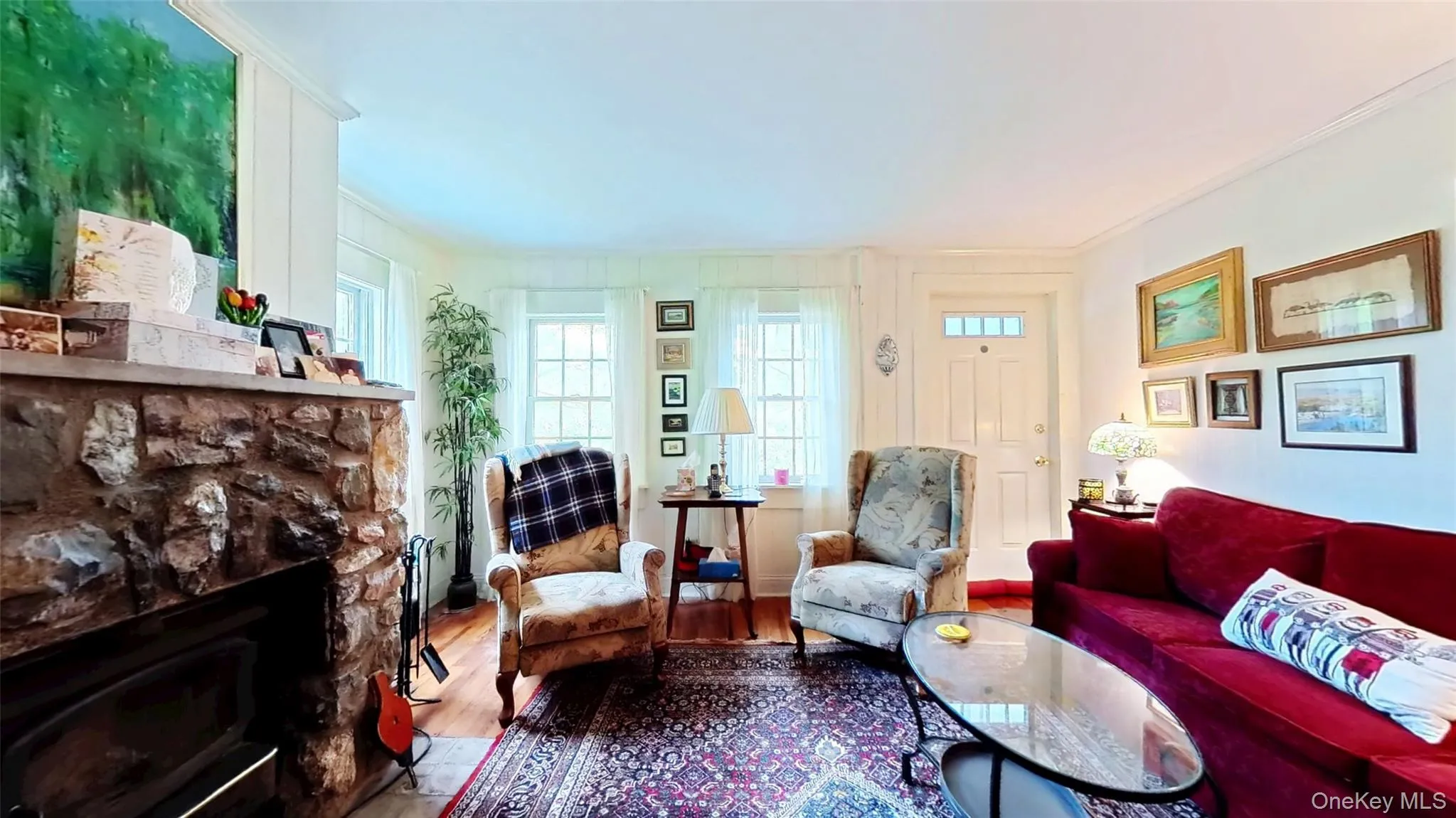 Living area with wood finished floors, ornamental molding, and a working wood fireplace Living area with wood finished floors, ornamental molding, and a working wood fireplace