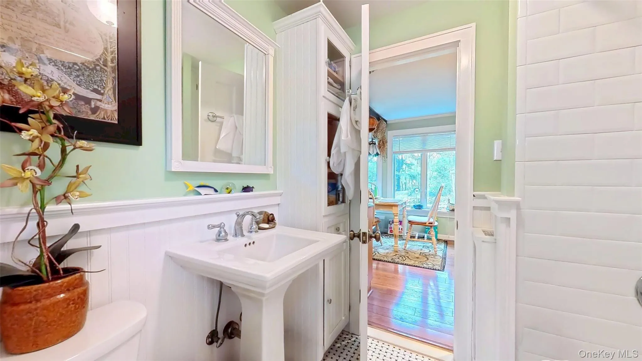 Remodeled with a wainscoted wall, pedestal sink, tiled tub with shower and storage Remodeled with a wainscoted wall, pedestal sink, tiled tub with shower and storage
